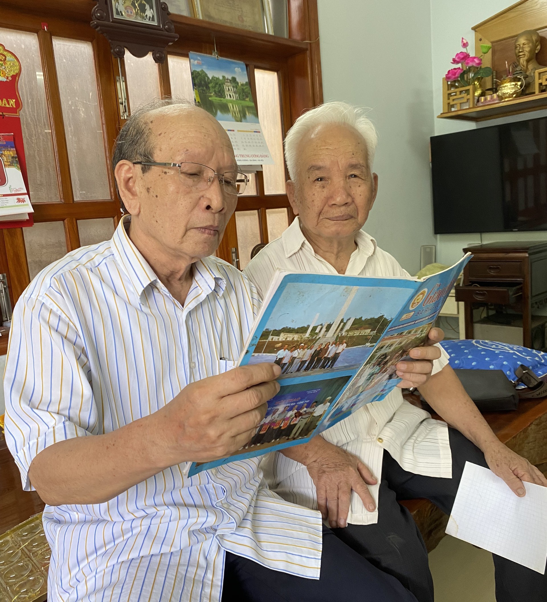 Trò Luyện, học trò cưng của thầy, đọc to cho cả cô thầy và các bạn cùng nghe bài báo viết về thầy Phan Kính.