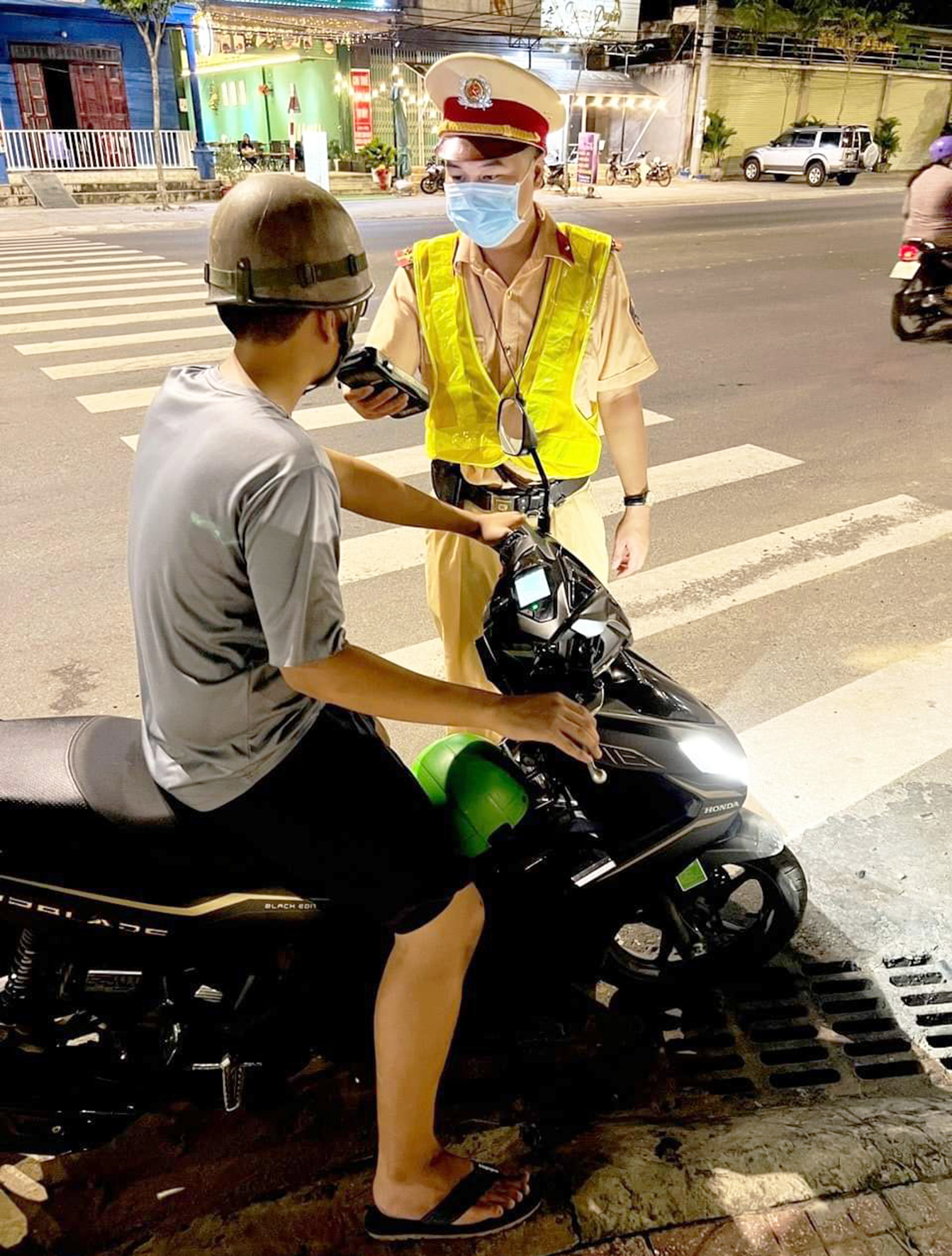 Lực lượng CSGT kiểm tra nồng độ cồn đối với 1 người điều khiển xe mô tô