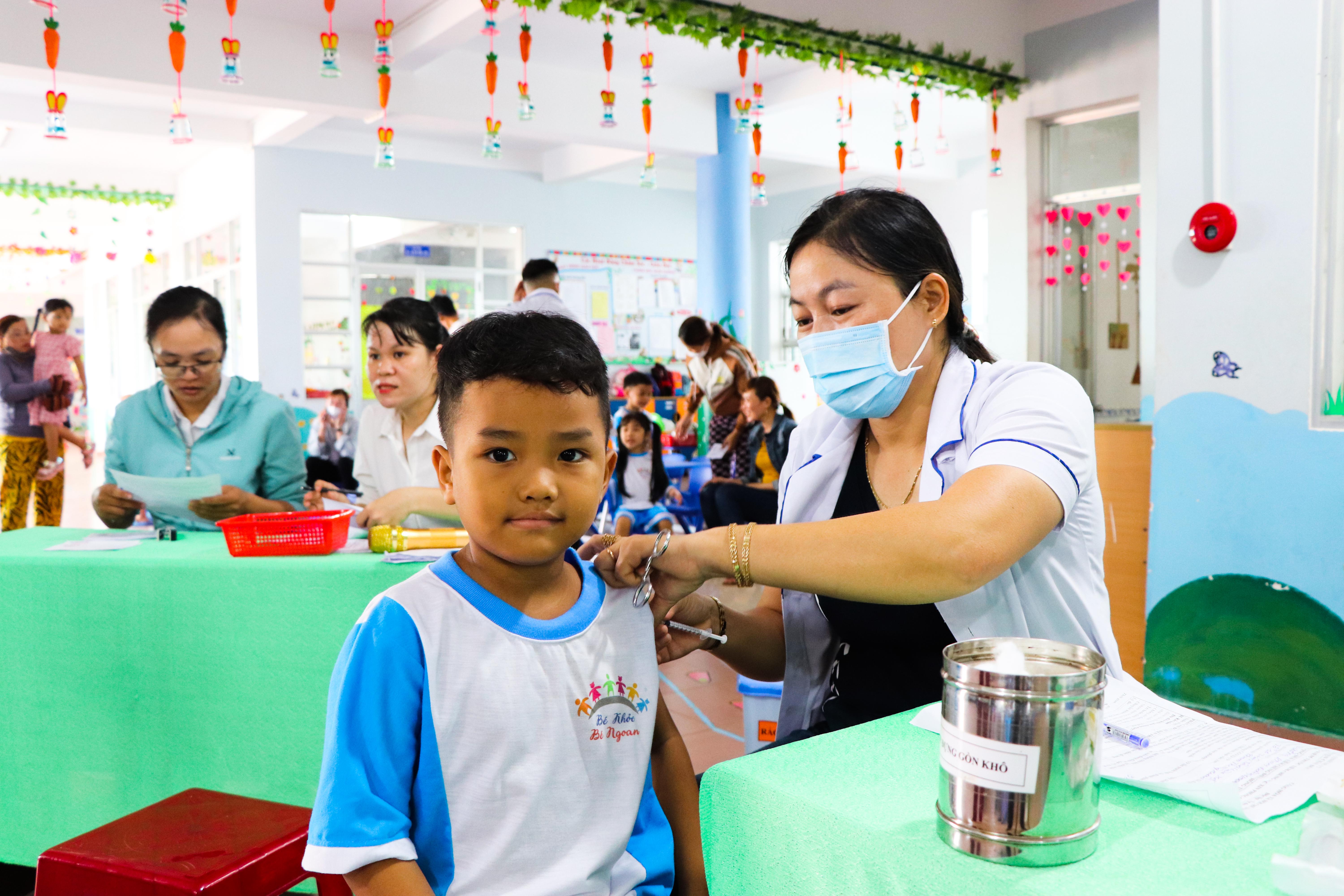 Nhân viên y tế tiêm vắc xin phòng COVID-19 cho trẻ 5 tuổi tại Trường Mầm non Tuổi Ngọc (xã Bàu Chinh).