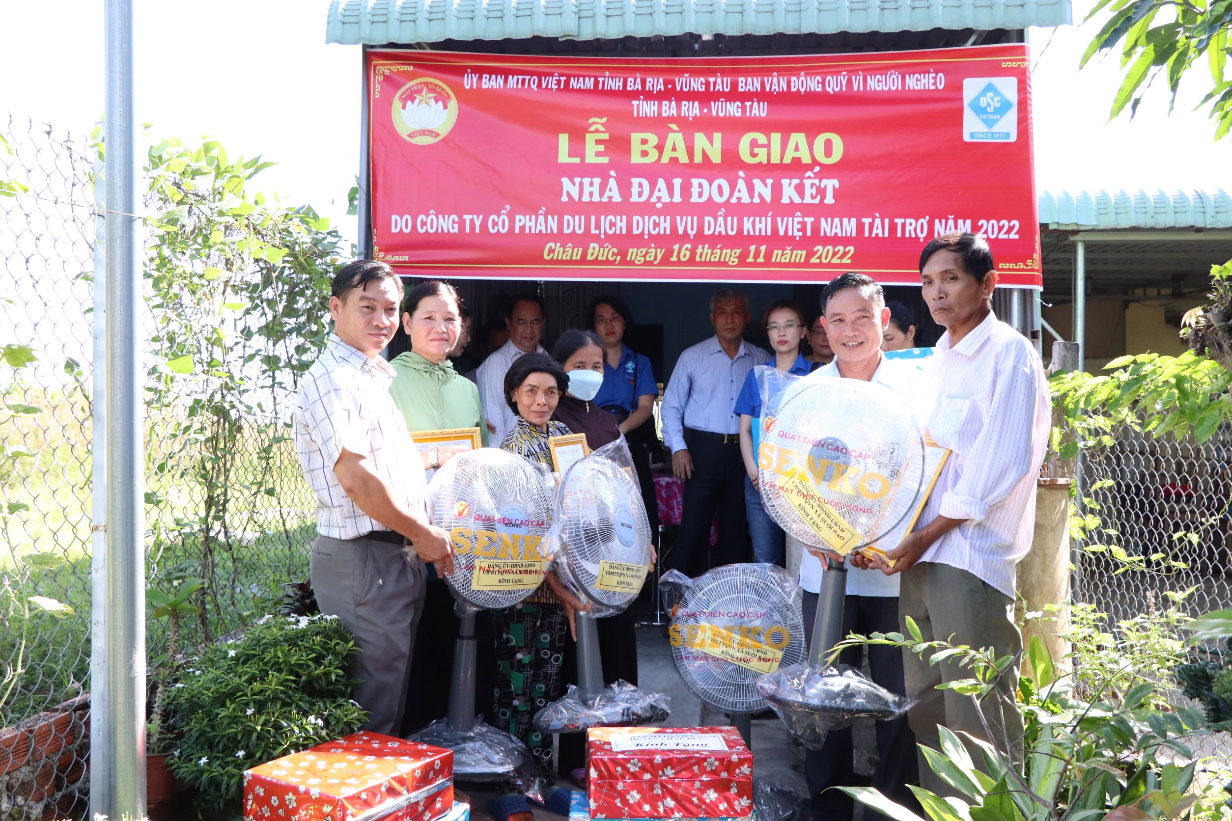 Ông Nguyễn Trung Hiếu (bên trái), Phó Chủ tịch UBND xã Suối Rao trao tặng quà cho các gia đình tại lễ bàn giao nhà Đại đoàn kết.