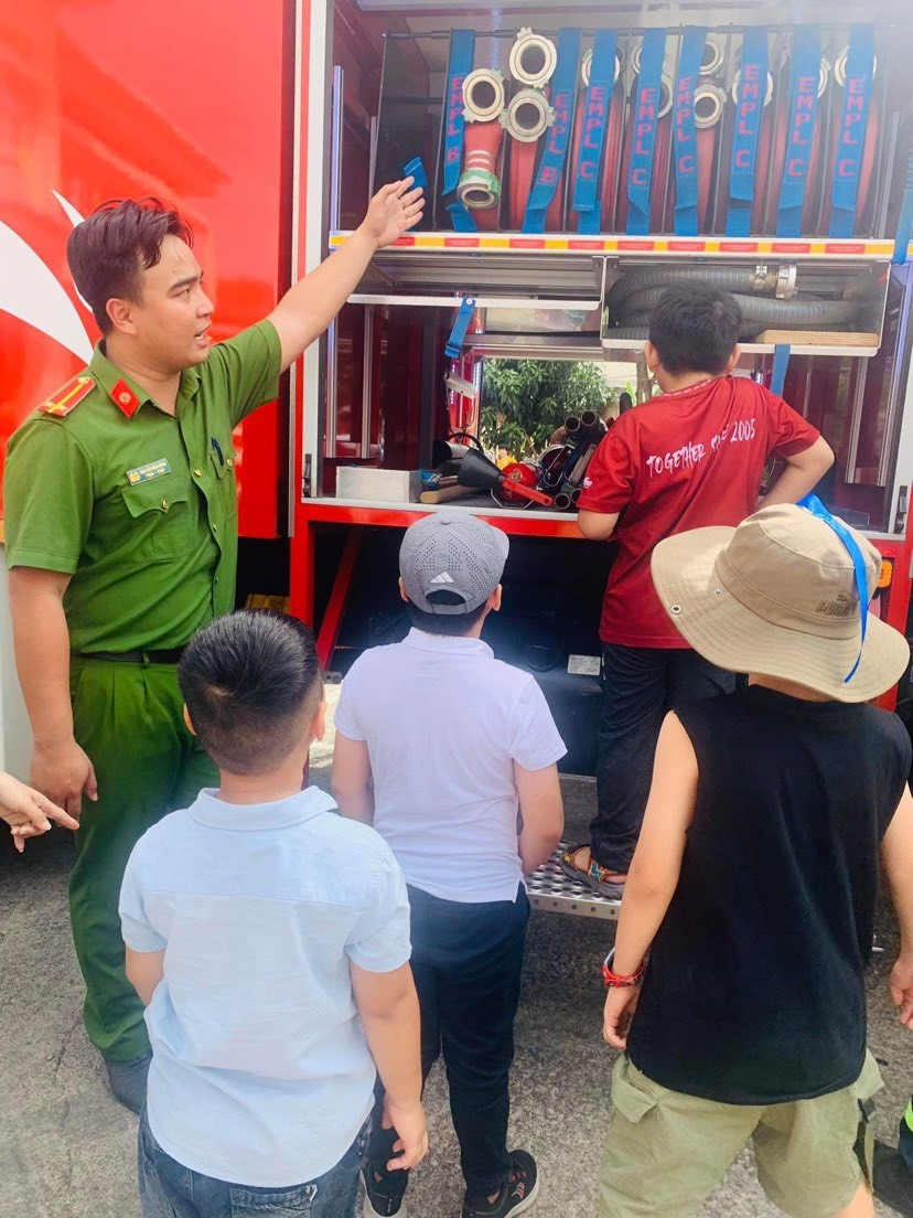 Các em thiếu nhi được chiến sỹ phòng cháy chữa cháy giới thiệu các vật dụng chuyên dụng phòng cháy chữa cháy và cứu hộ cứu nạn.