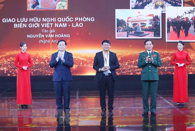 Đại tướng Phan Văn Giang, Ủy viên Bộ Chính trị, Phó Bí thư Quân ủy Trung ương, Bộ trưởng Bộ Quốc phòng và Bí thư Trung ương Đảng, Trưởng ban Tuyên giáo Trung ương Nguyễn Trọng Nghĩa trao giải nhất cho tác giả Nguyễn Văn Hoàng. (Ảnh: Phương Hoa/TTXVN)
