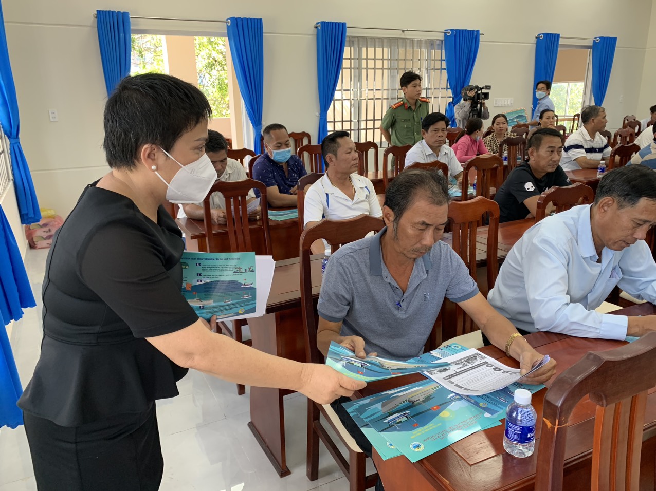Cán bộ xã Phước Tỉnh phát tờ rơi “Những điều chủ tàu cá và ngư dân hoạt động trên biển cần ghi nhớ thực hiện” cho chủ tàu cá, thuyền trưởng tham gia hội nghị.
