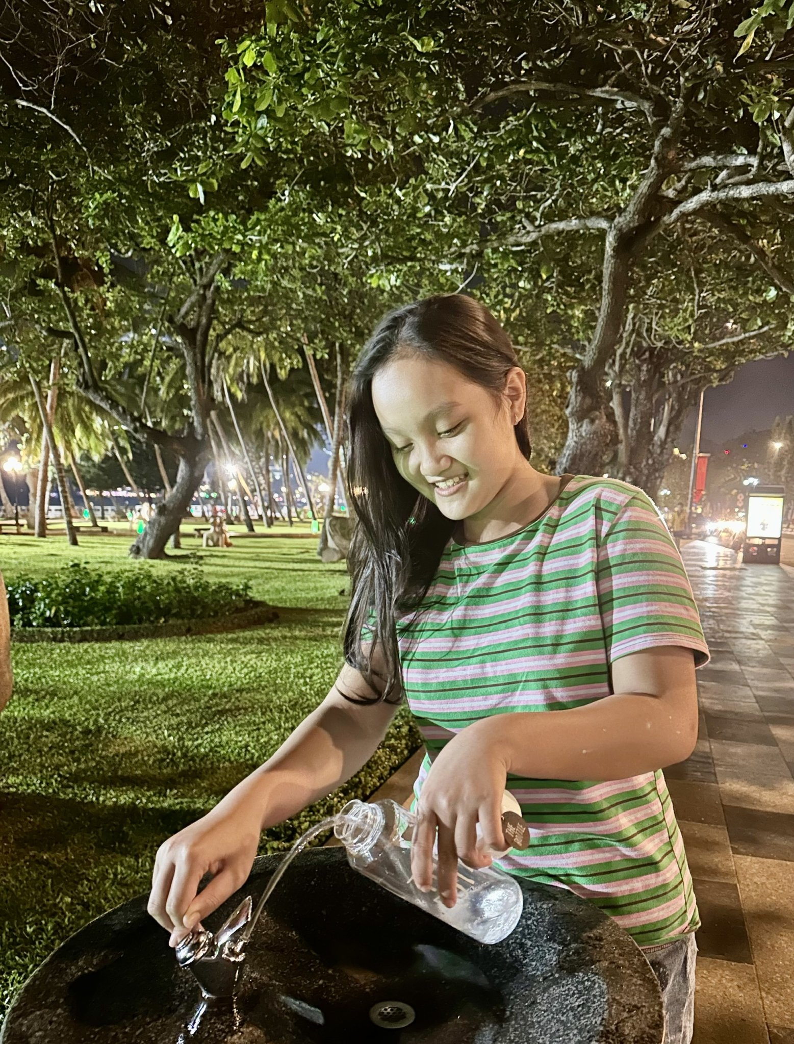 Một em học sinh lớp 6 lấy nước vào chai để uống từ trụ vòi nước uống đặt tại Công viên Bãi Trước (TP. Vũng Tàu).