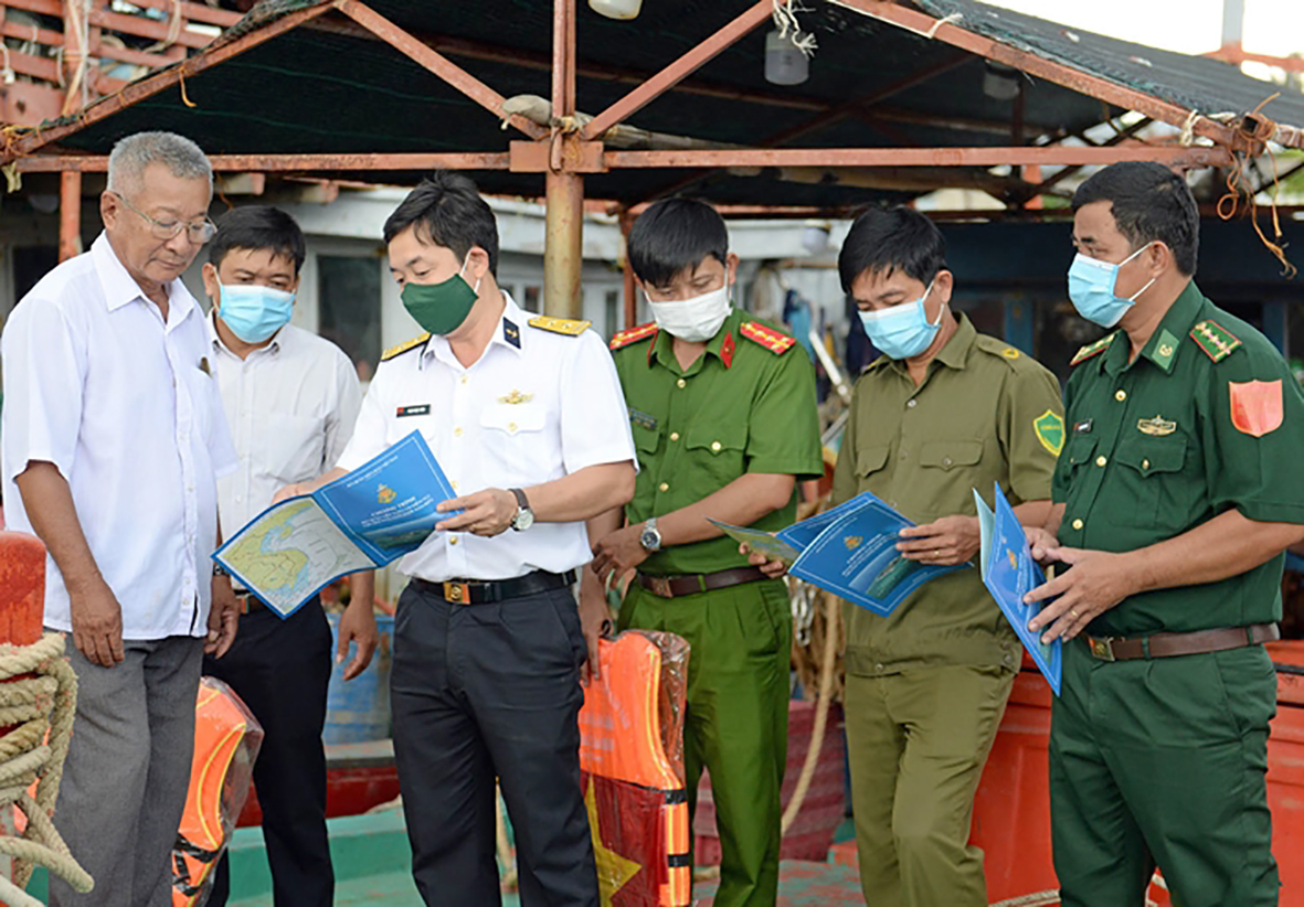 Cán bộ, chiến sĩ Vùng 2 Hải quân tuyên truyền chống khai thác bất hợp pháp, không báo cáo và không theo quy định cho ngư dân.