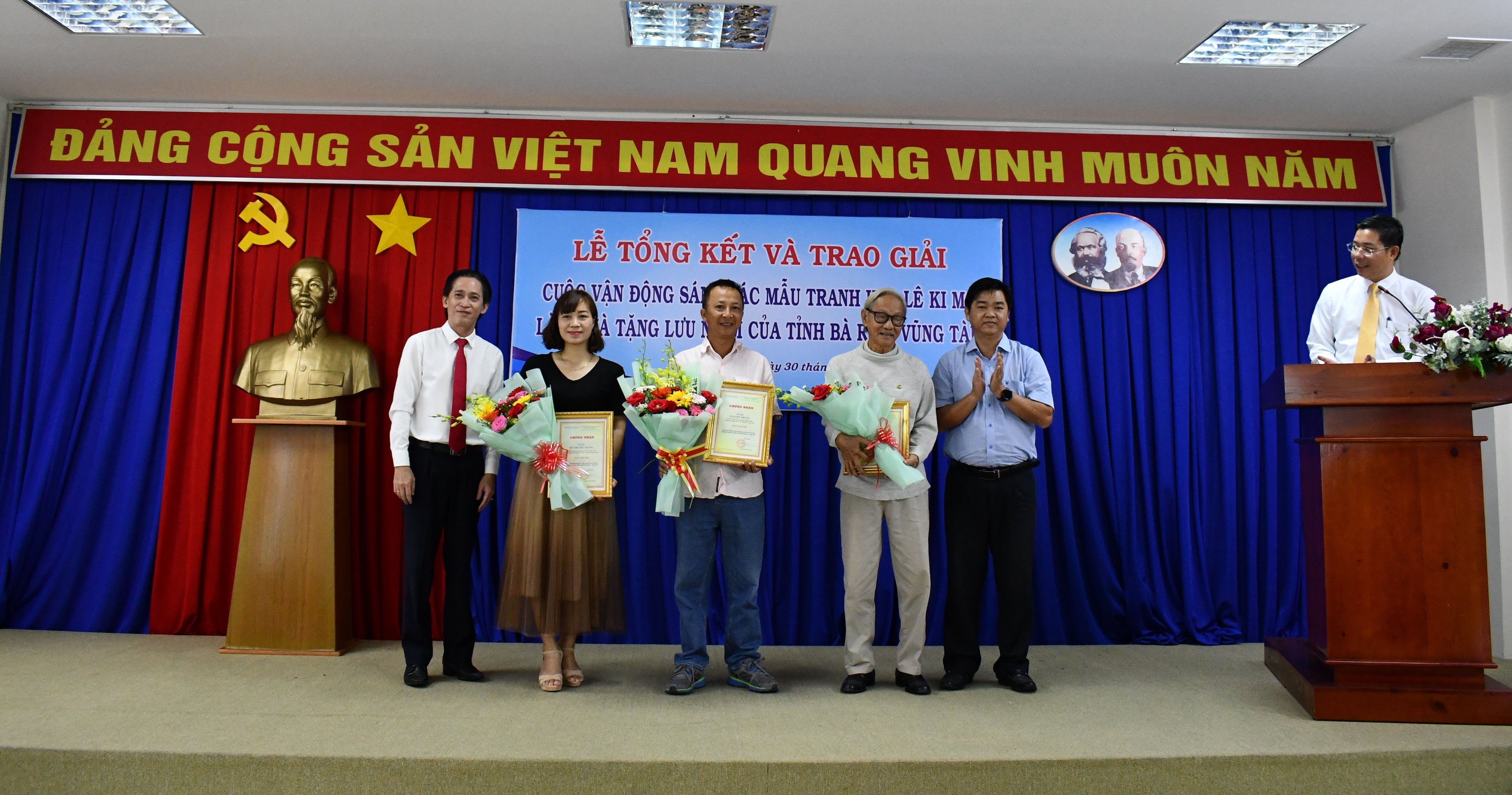 Ông Lê Văn Minh, Phó Ban Tuyên giáo Tỉnh ủy và ông Huỳnh Đức Dũng tặng hoa chúc mừng và trao chứng nhận đạt giảii Nhì đến tác giả.