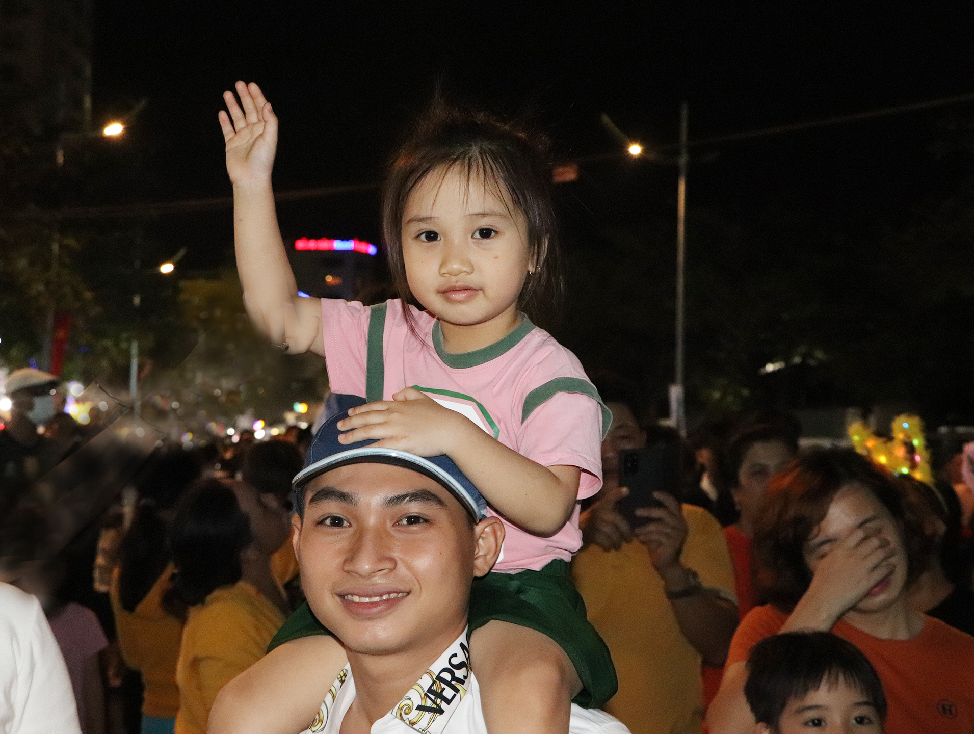 Những em nhỏ được cha mẹ cõng trên vai để có thể xem rõ hơn màn trình diễn trên sân khấu.
