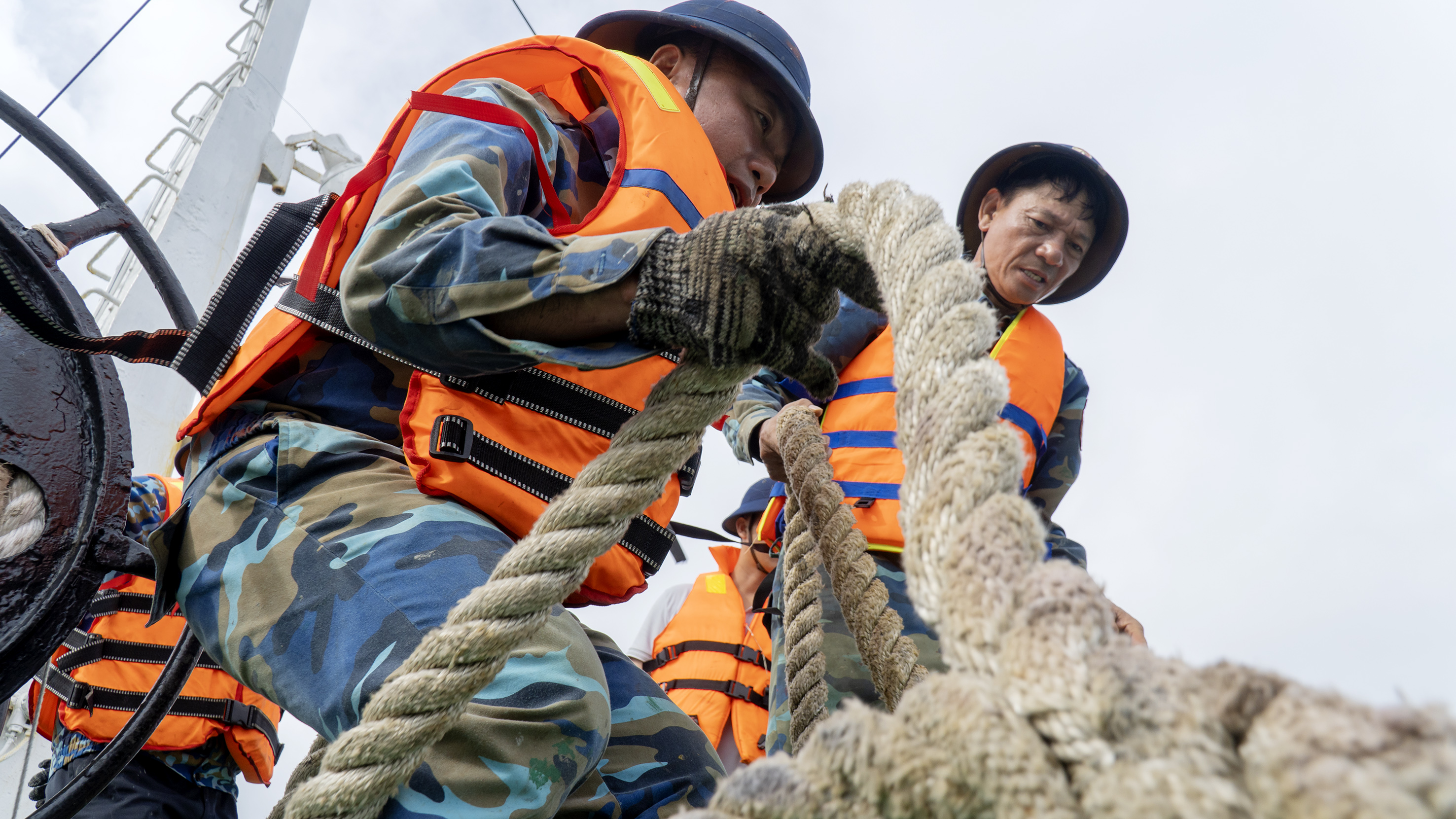 Thực hiện phương án chằng níu tàu với nhà giàn, các thủy thủ tàu phải đối mặt với nguy hiểm đến tính mạng do dây căng. Thủy thủ trưởng tàu Trường Sa 10 Bùi Sỹ Sáu (bên phải) chia sẻ: Dây chằng néo giữa nhà giàn và tàu căng, khi đứt dây sẽ bắn nhanh như vận tốc của một viên đạn. 52 tuổi đời, 33 tuổi quân, thủy thủ Võ Sỹ Sáu đã tham gia nhiều chuyến công tác trên biển; luôn khắc phục khó khăn, tuân thủ nghiêm mệnh lệnh, kế hoạch của cấp trên, chủ động, linh hoạt, sáng tạo và hoàn thành xuất sắc nhiệm vụ được giao.