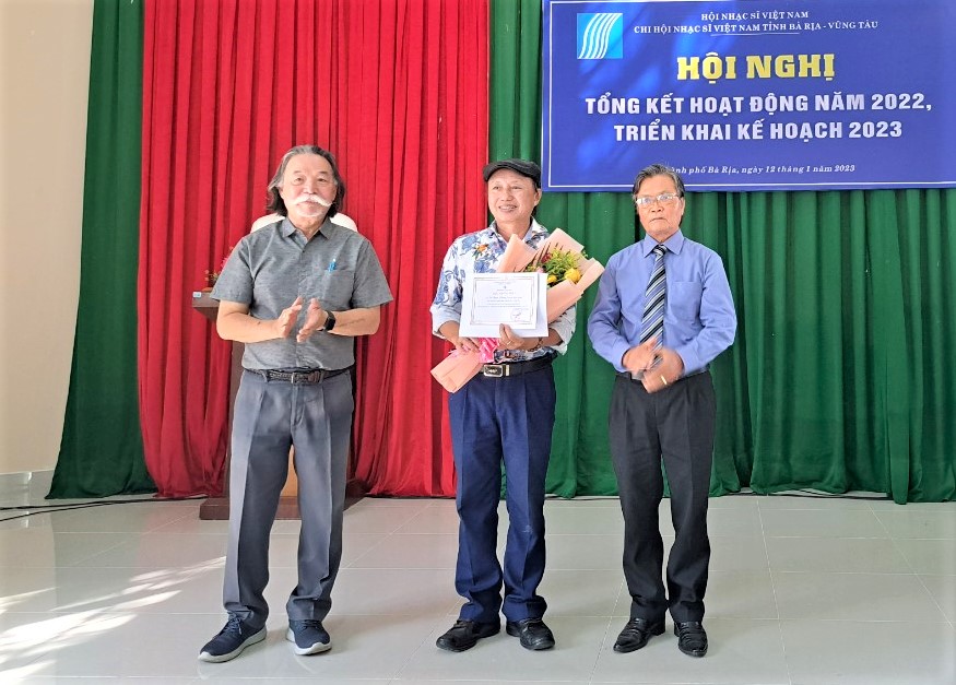 Ông Hoàng Lương, Phó chủ tịch Hội Văn học Nghệ thuật và ông Võ Văn Tư, Chi hội trưởng Hội NSVN tỉnh trao hoa và quyết định kết nạp hội viên mới.