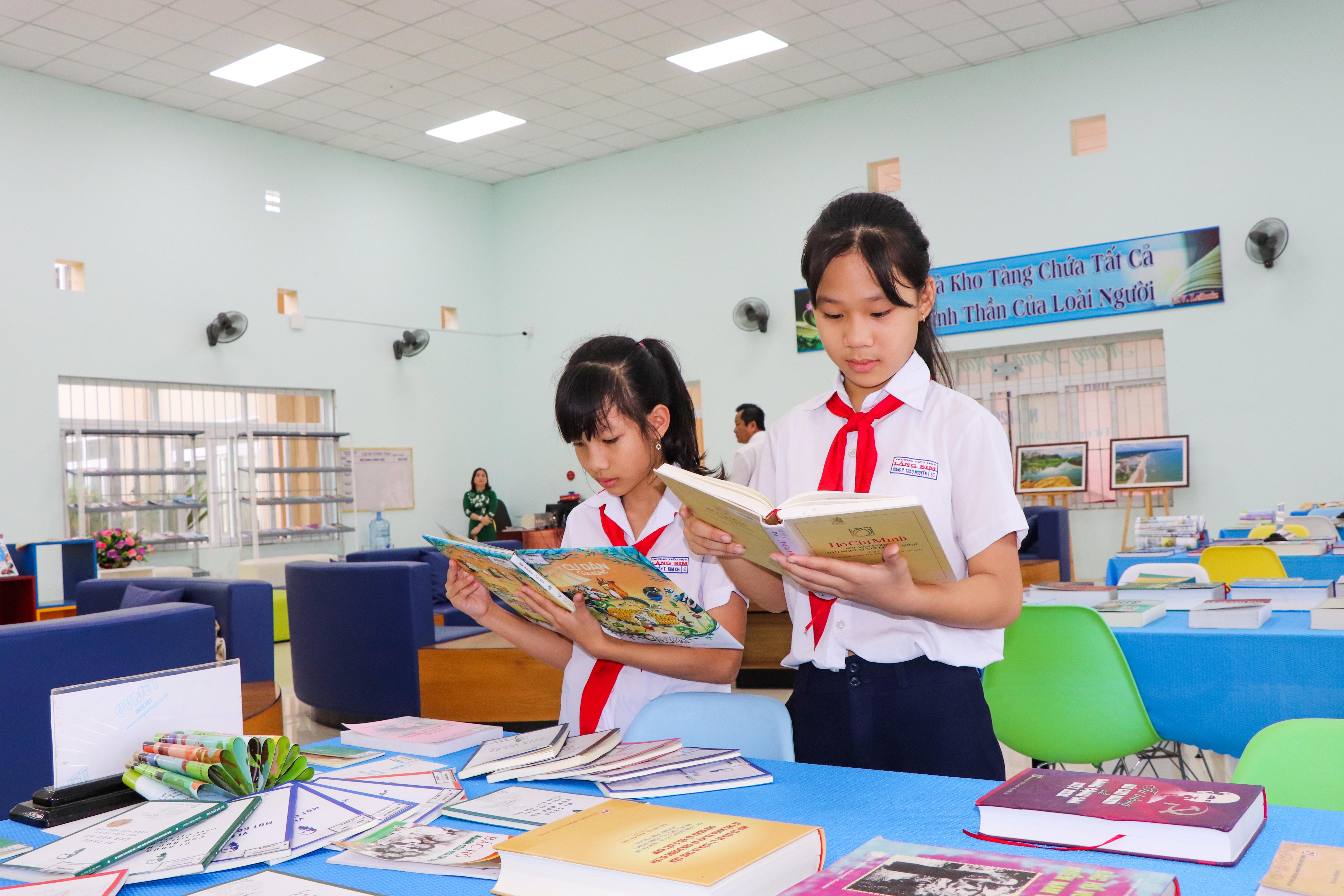 Các bạn HS Trường TH Láng Sim chăm chú đọc các tài liệu viết về Chủ tịch Hồ Chí Minh tại triển lãm.