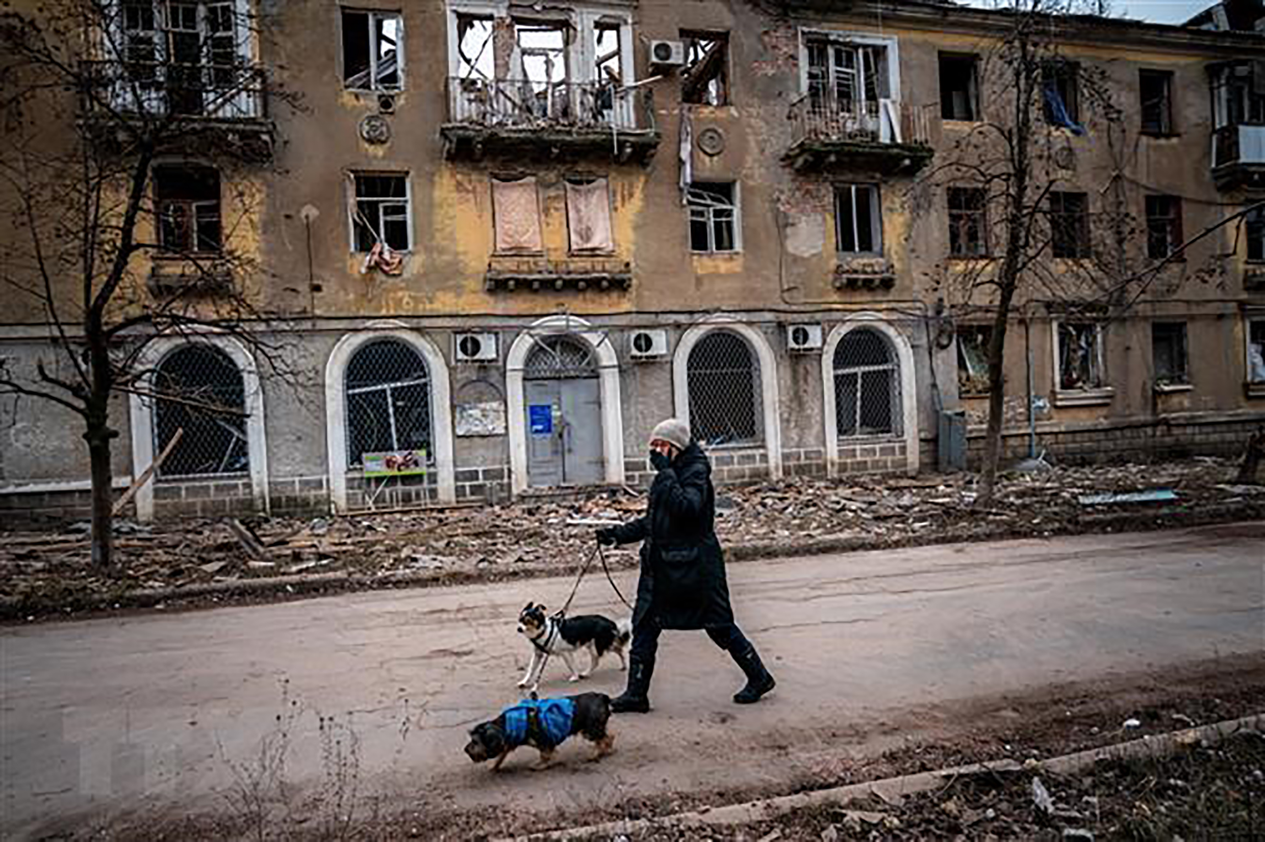 Người dân di chuyển qua tòa nhà bị hư hại trong xung đột Nga-Ukraine tại Chasiv Yar, miền Đông Ukraine ngày 5/1/2023.