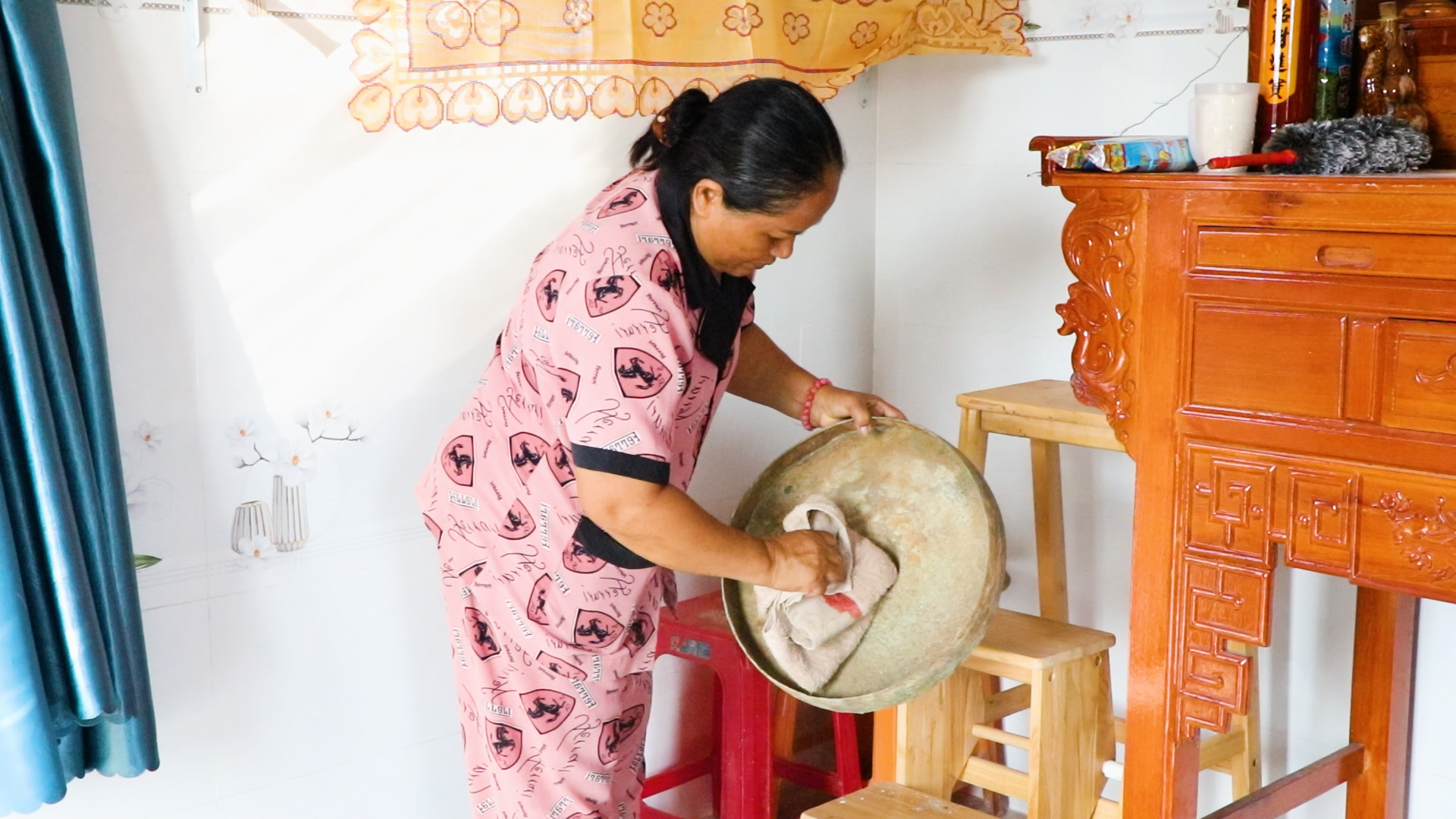 Bà Đào thị Dương (vợ ông Thời), lau chùi chiếc cồng chiêng cổ mà đã được gia đình lưu giữ cẩn thận qua bao thế hệ.