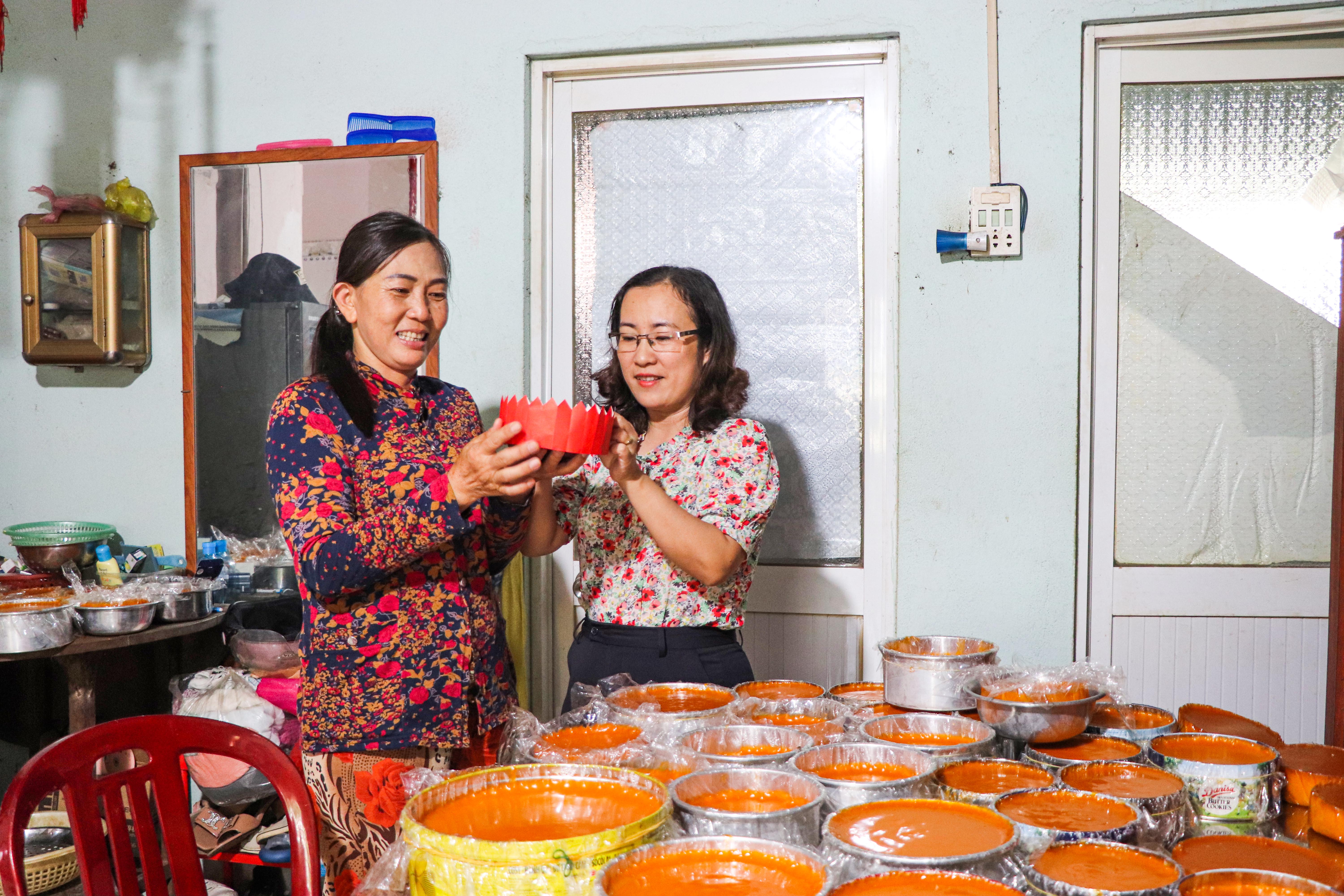 Bà Chềnh Châu Thủy (bên trái) giới thiệu món bánh tổ với bà Lê Thị Yến Thương, Phó Chủ tịch UBND xã Láng Lớn.