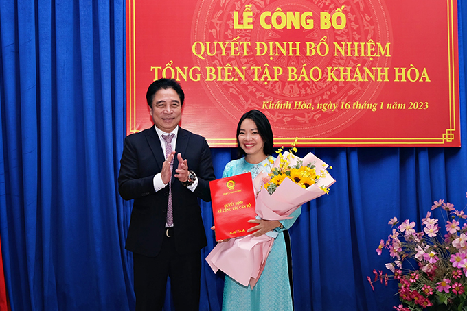 Ông Nguyễn Khắc Toàn, Phó Bí thư Thường trực Tỉnh ủy Khánh Hòa trao quyết định bổ nhiệm và tặng hoa chúc mừng bà Thái Thị Lệ Hằng. Ảnh: Thành An.