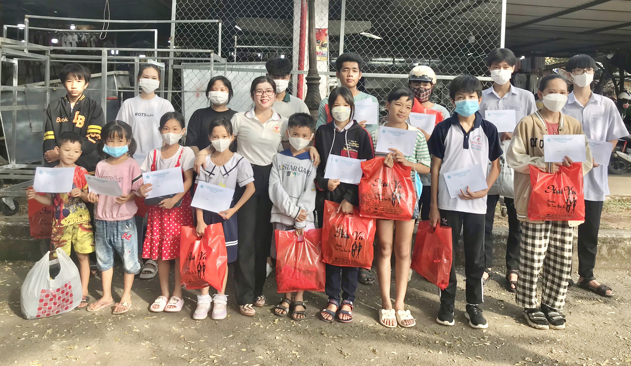 Trẻ mồ côi vui vẻ chụp hình lưu niệm cùng bà Trần Thị Ái Hà, Chủ tịch Hội LHPN TX.Phú Mỹ (hàng dưới, thứ 5 từ trái qua) sau khi được mua sắm đồ Tết