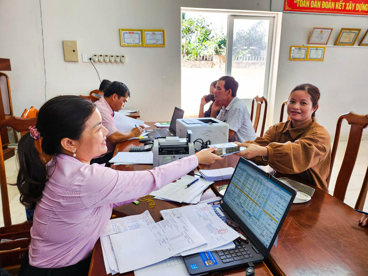 Nhân viên Phòng Giao dịch Ngân hàng Chính sách xã hội huyện Châu Đức trao vốn vay giải quyết việc làm cho hộ dân trên địa bàn xã Suối Nghệ.