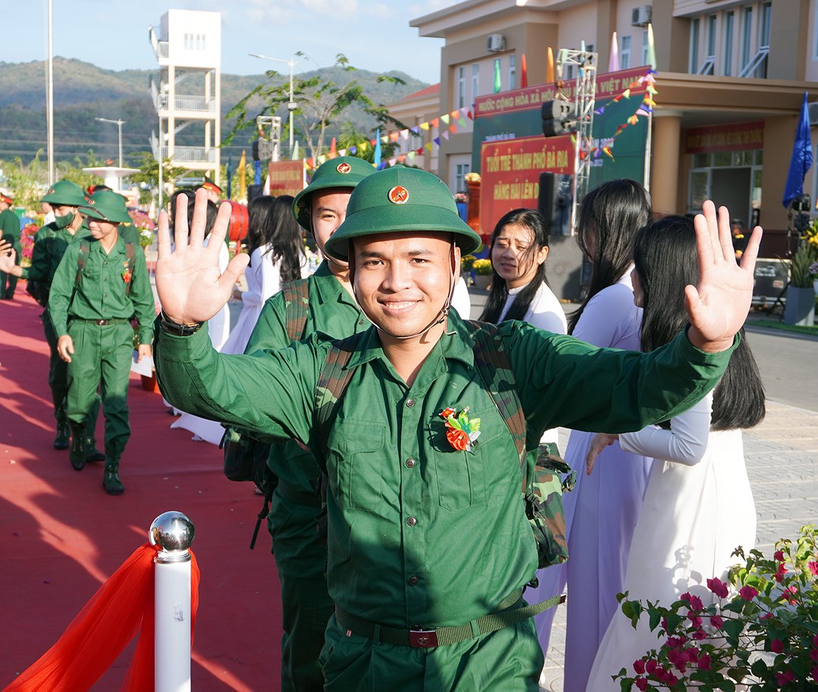 Tân binh TP. Bà Rịa vẫy tay chào người thân trước lúc lên đường. Ảnh: PHÚ XUÂN.