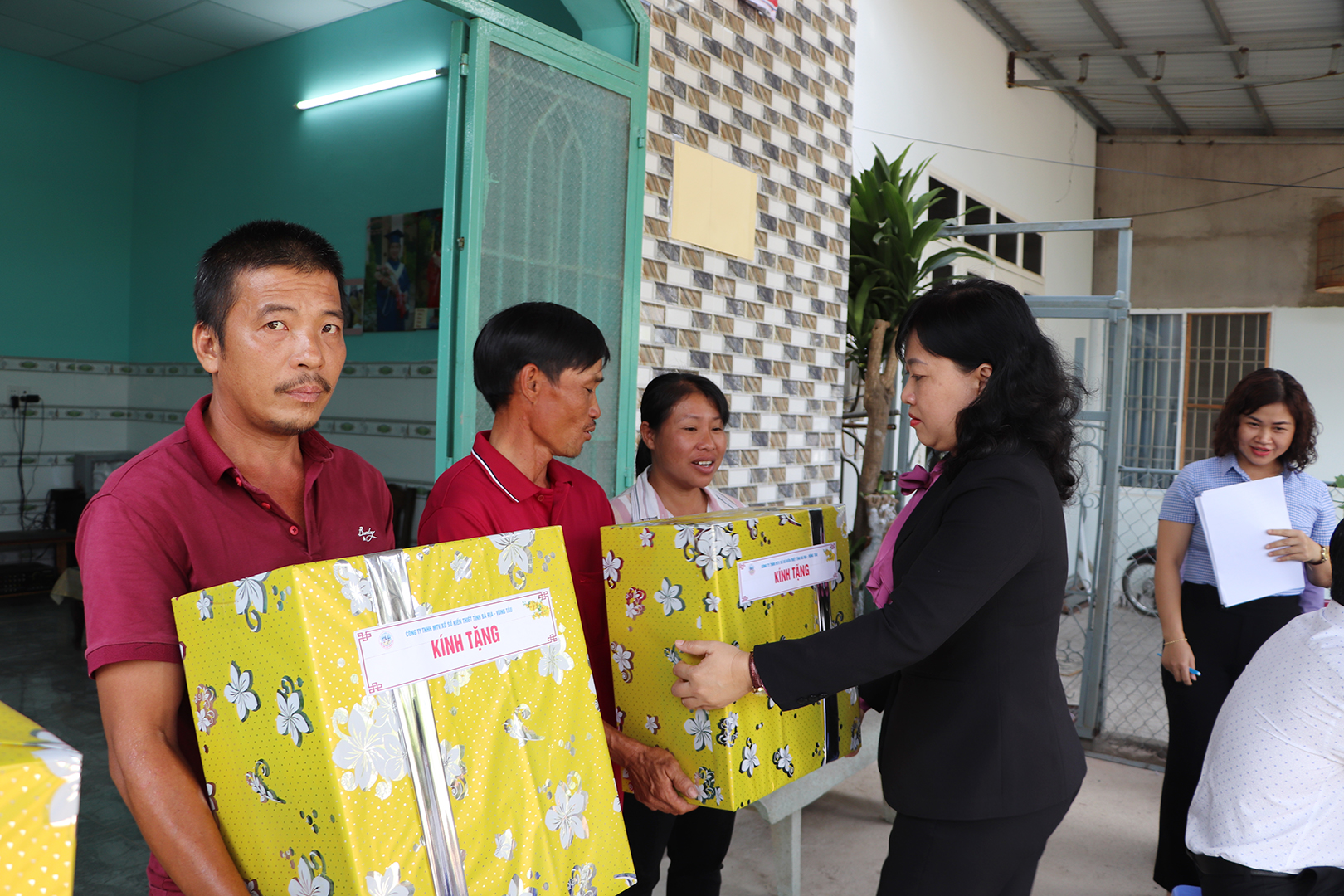 Bà Phạm Thị Kim Thương, Phó Giám đốc ông ty TNHH MTV Xổ số Kiến thiết tỉnh Bà Rịa-Vũng Tàu tặng quà đến 2 gia đình ông Thuận và ông Phong nhân dịp nhận nhà mới.