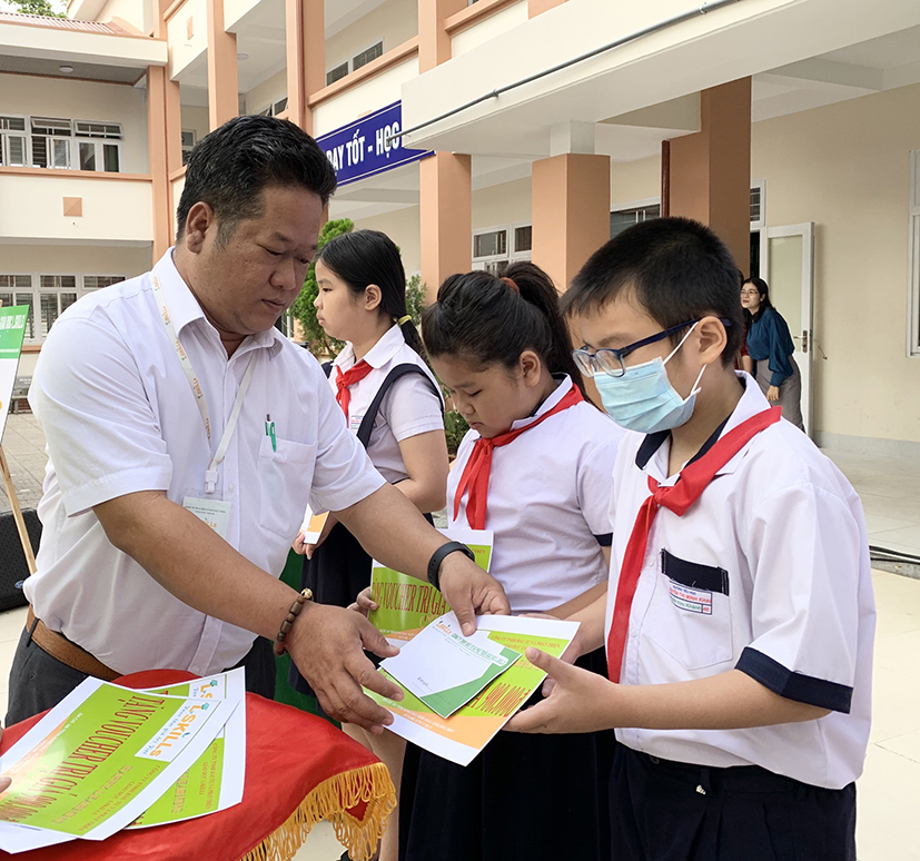 Ông Lê Văn Lời, Giám đốc Công ty TNHH Đầu tư và Phát triển giáo dục L.SKILLs tặng quà cho các em HS khó khăn của Trường TH Nguyễn Thị Minh Khai.