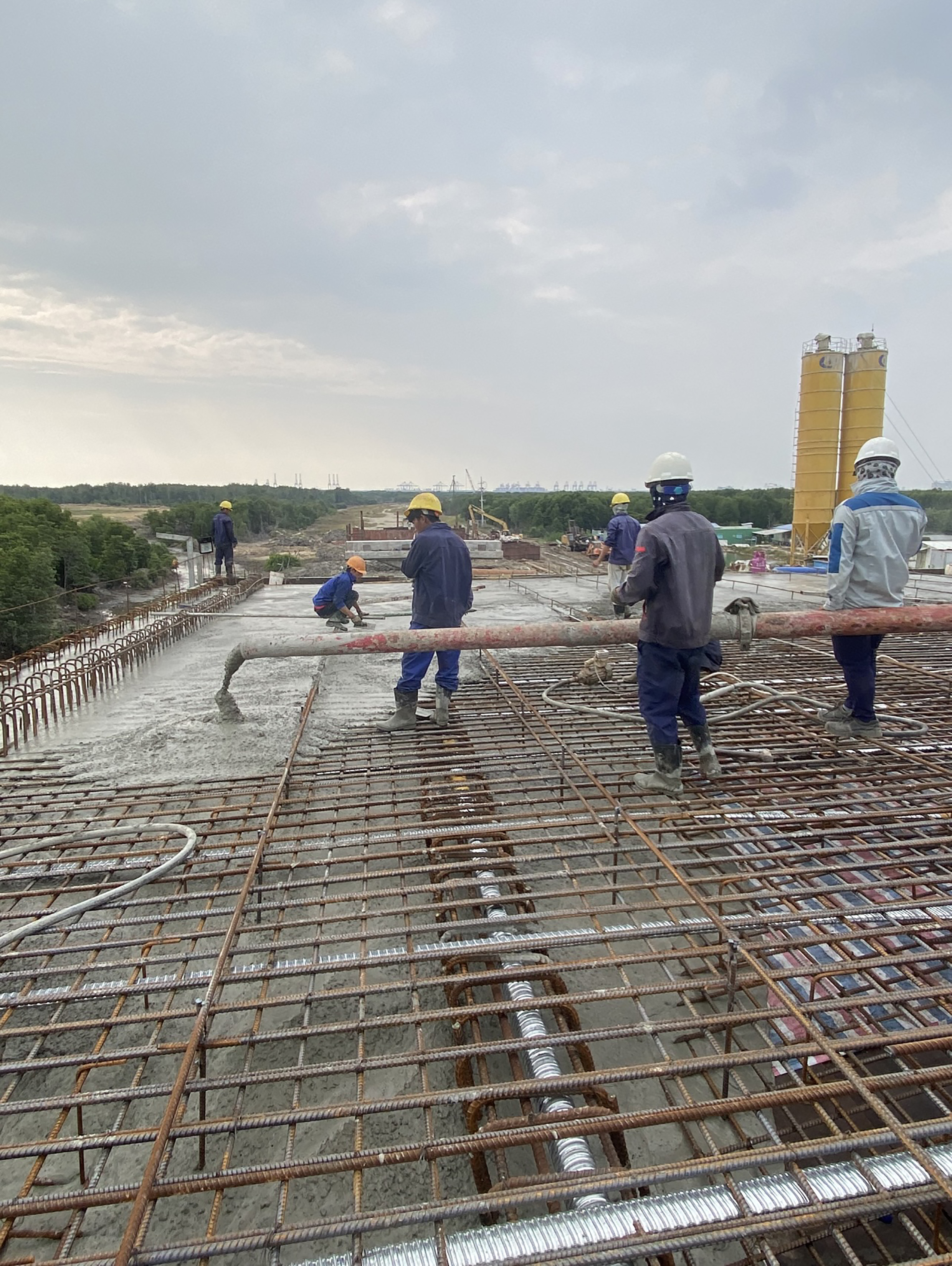 Các nhà thầu đang đẩy nhanh thi công đường 911B. Trong ảnh: Công nhân thi công dầm cầu Mỏ Nhát.