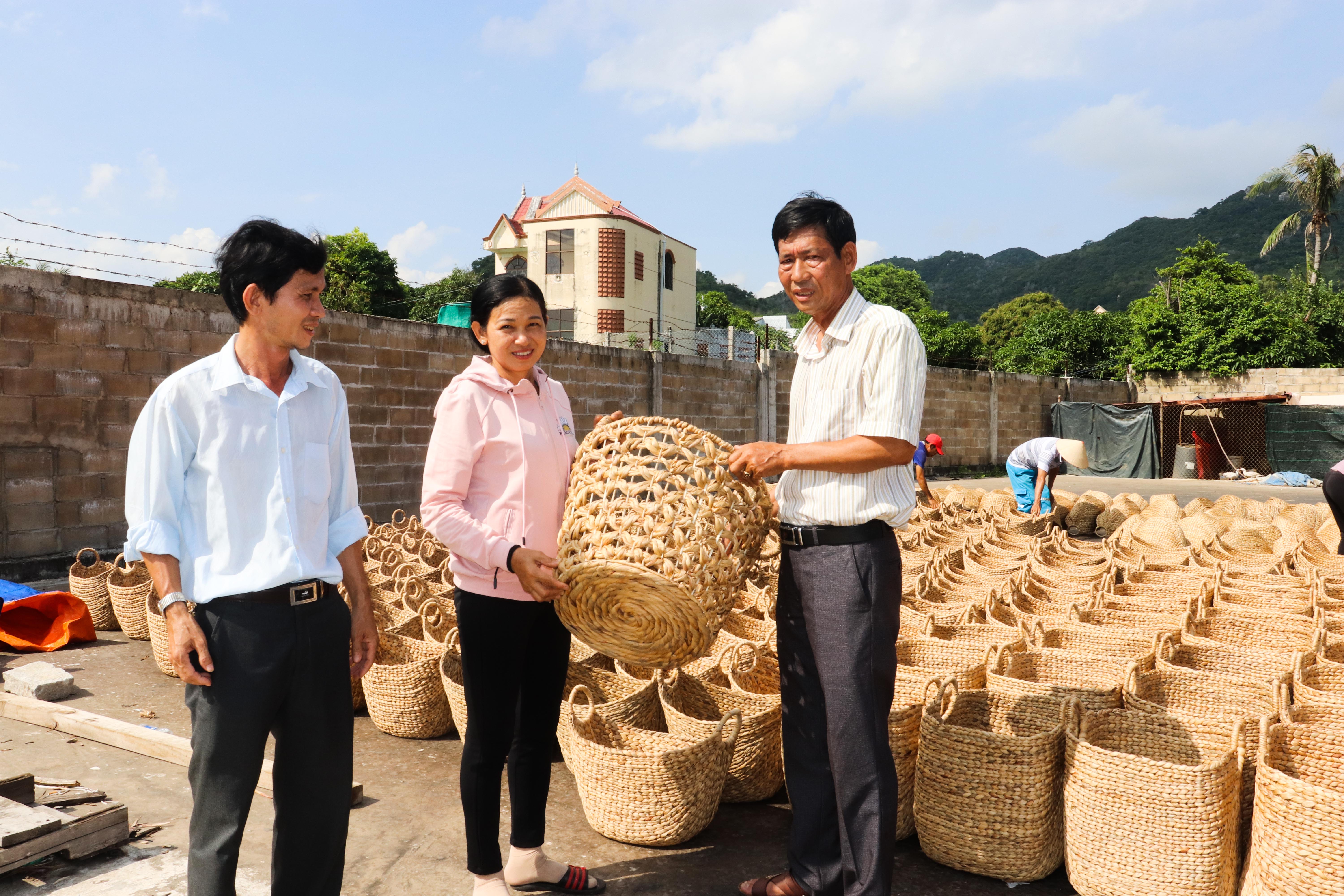 Cơ sở đan giỏ lục bình của ông Lê Văn Đạt (bên phải), đã tạo việc làm cho hàng trăm lao động địa phương.