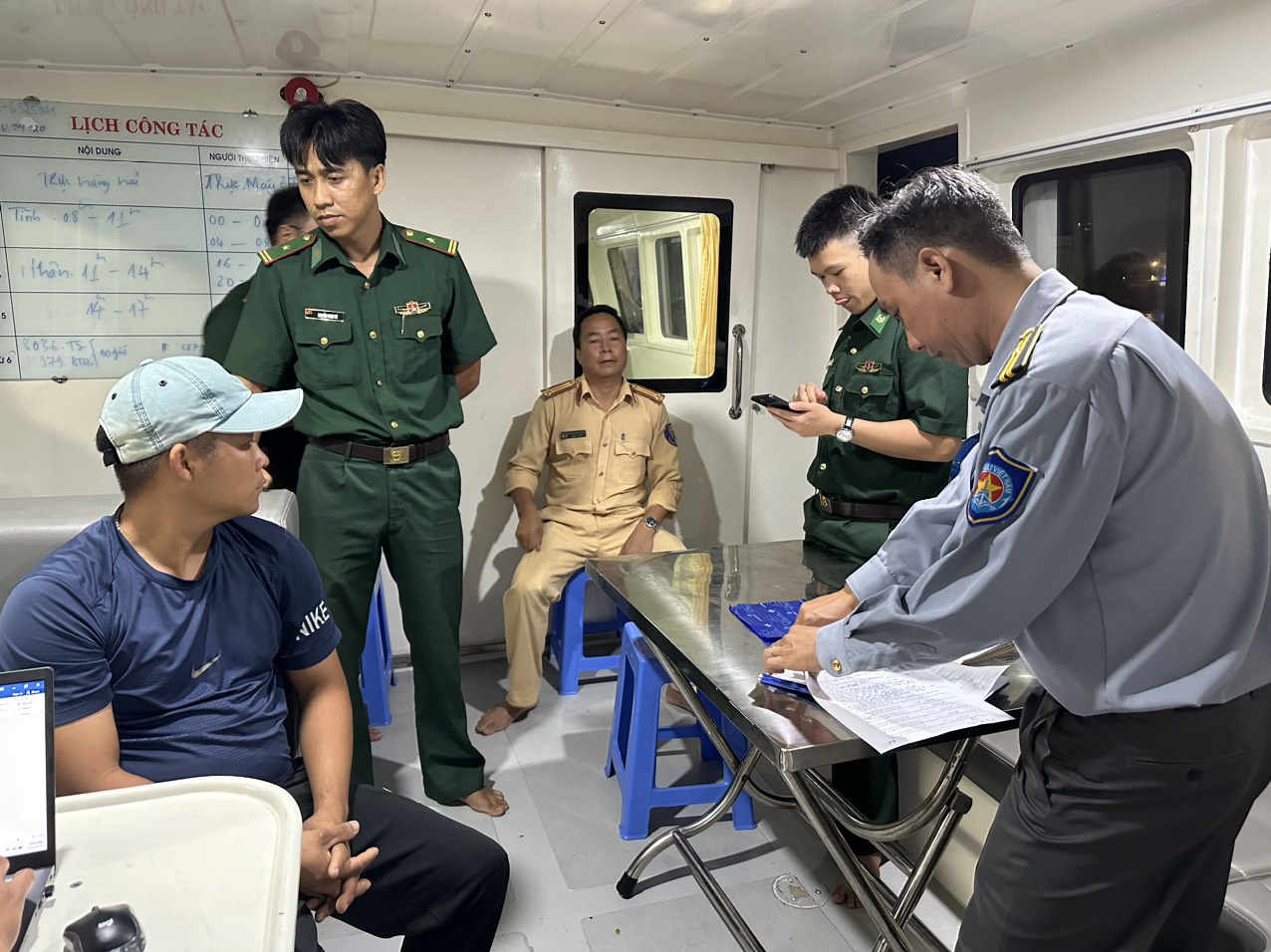 Lực lượng chức năng Chi cục Thủy sản tỉnh và Đồn Biên phòng Bến Đá làm việc với thuyền trưởng Trần Văn Đức (tàu cá BĐ 92109 TS).
