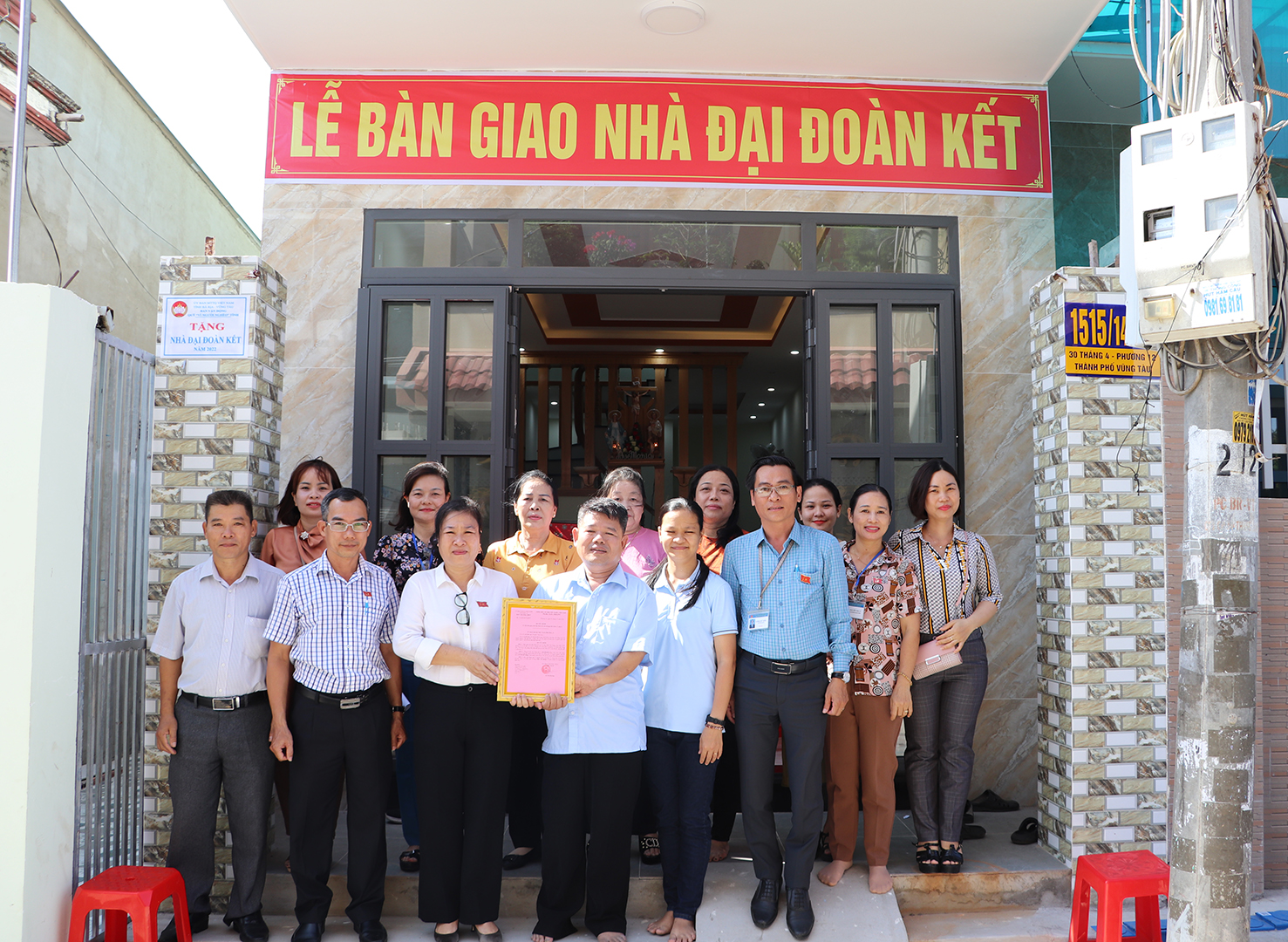 Các đại biểu chụp hình lưu niệm trong buổi lễ bàn giao nhà tới ông Trần Văn Hưng.