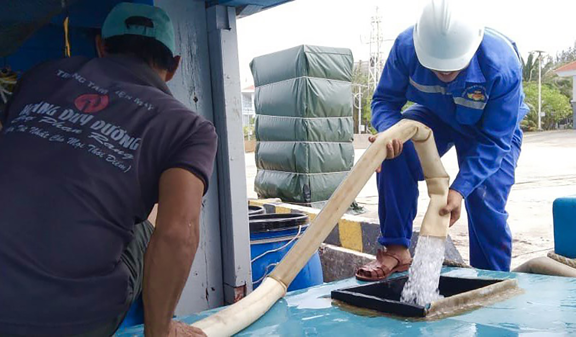 Nhân viên Trung tâm dịch vụ Hậu cần - Kỹ thuật đảo Trường Sa cung cấp nước ngọt miễn phí cho ngư dân. Ảnh: CTV