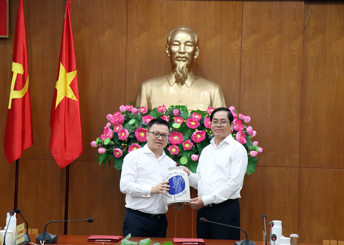 Tổng Biên tập Báo Nhân dân Lê Quốc Minh tặng quà lưu niệm tới Bí thư Tỉnh ủy Phạm Viết Thanh.