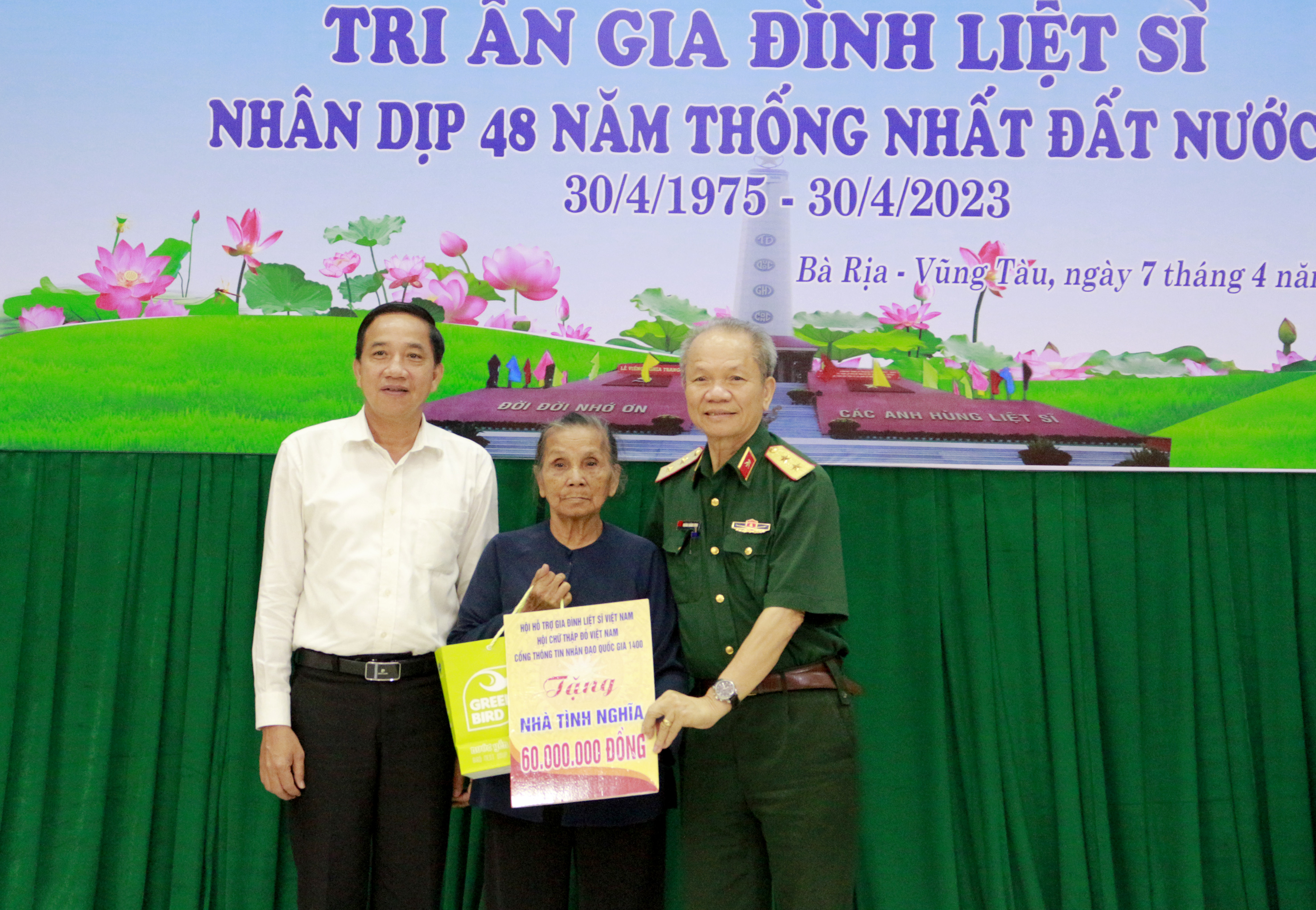 Trung tướng Hoàng Khánh Hưng, Chủ tịch Hội Hội Hỗ trợ gia đình liệt sĩ Việt Nam (bìa phải) và ông Trần Quốc Khánh, Giám đôc Sở LĐTB & XH trao tặng quà cho bà Trần Thị Đặng, TT. Đất Đỏ, huyện Đất Đỏ.