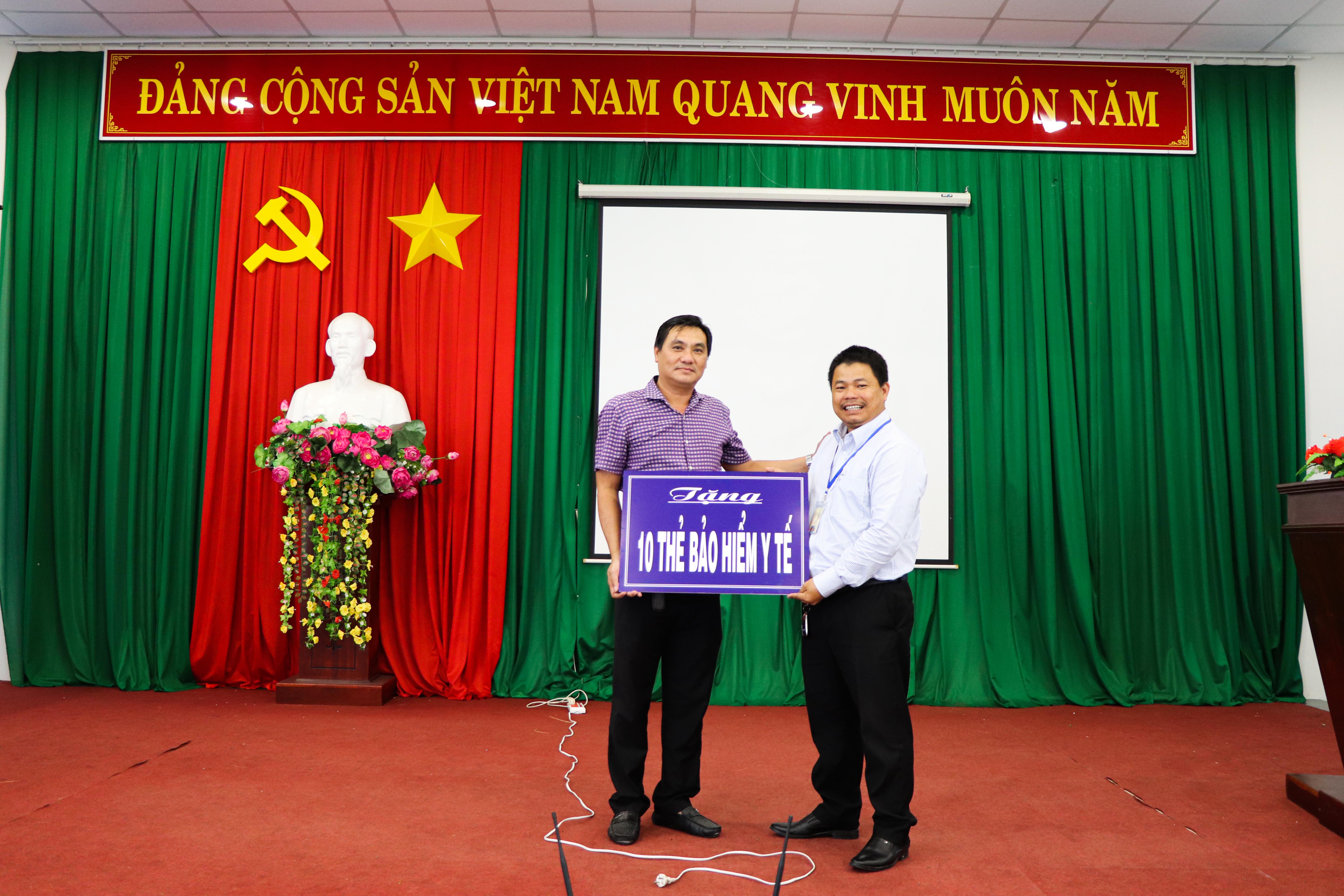 Ông Trần Quốc Nhẫn (bên trái), Phó Chủ tịch UBND TT. Long Hải nhận kinh phí mua thẻ BHYT cho người hoàn cảnh đặc biệt khó khăn do bác sĩ CK2 Trần Quốc Vương hỗ trợ.