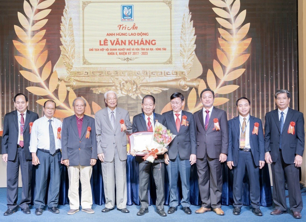 Anh hùng Lao động thời kỳ đổi mới Lê Văn Kháng, người nhận hoa, đứng giữa.