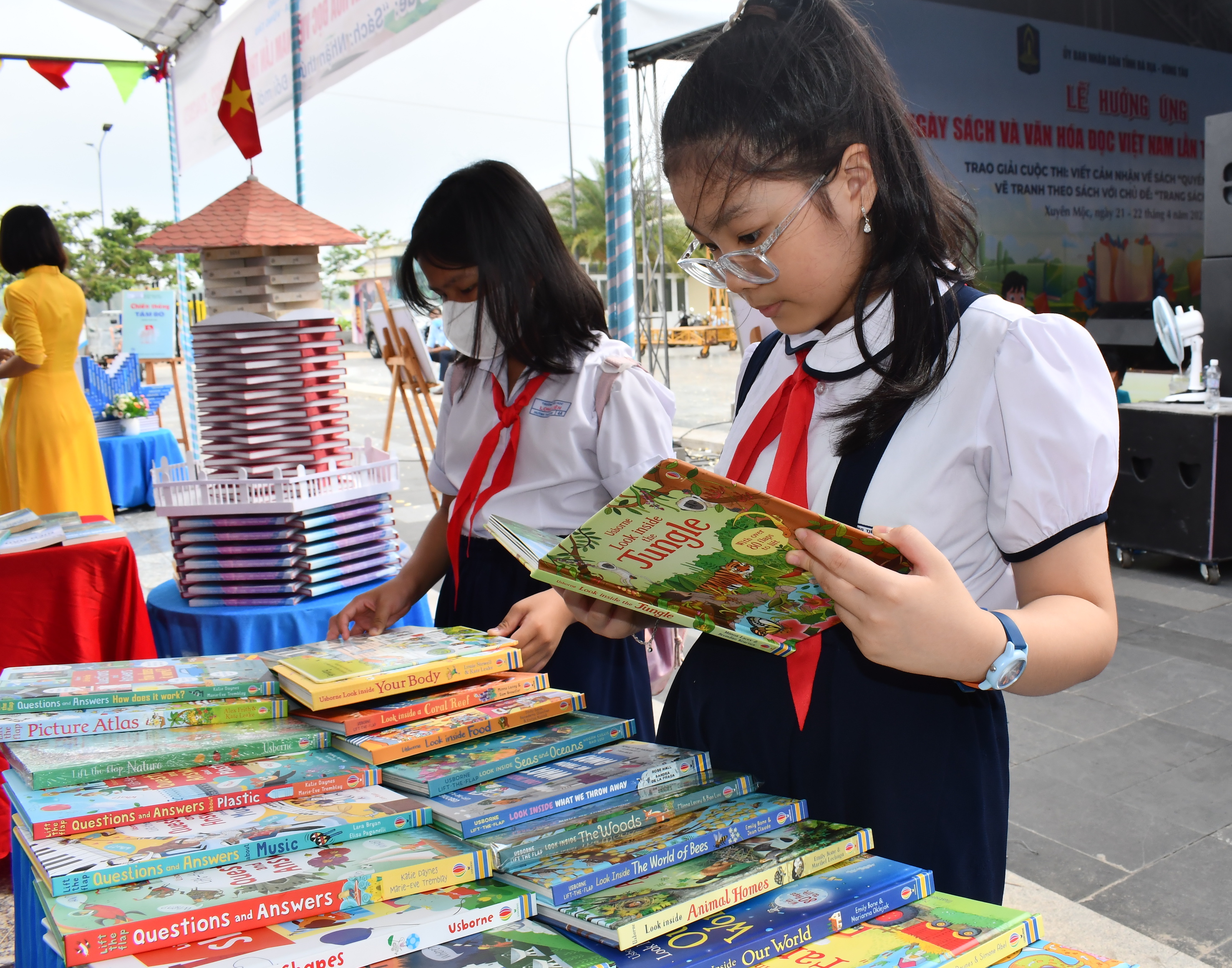 Các em HS đọc sách tại gian hàng trưng bày sách.