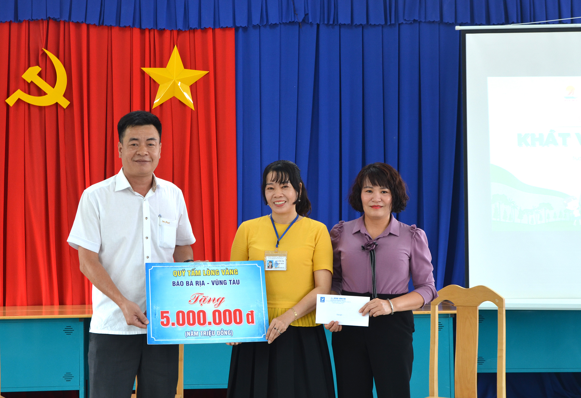 Ông Bùi Văn Cảnh, Trưởng Phòng Hành chính - trị sự và bà Phạm Thị Trà, Trưởng phòng Thời sự - Chính trị, Báo Bà Rịa - Vũng Tàu trao tiền và quà của Qũy Tấm lòng vàng Báo Bà Rịa-Vũng Tàu đến đại diện Trường Nuôi dạy trẻ khuyết tật tỉnh.