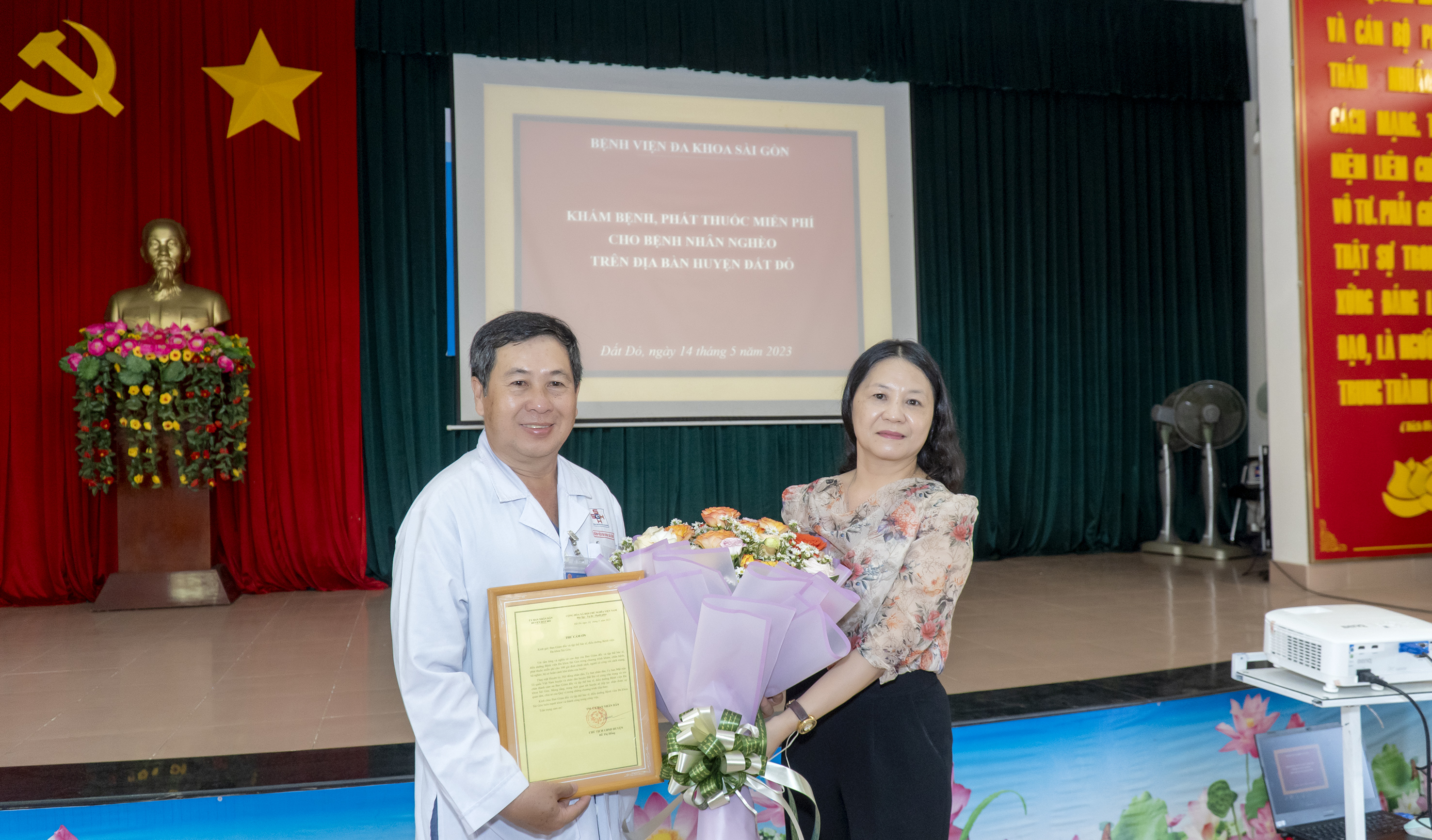 Đại diện huyện Đất Đỏ tặng hoa và thư cảm ơn Đoàn từ thiện Bệnh viện Đa khoa Sài Gòn.