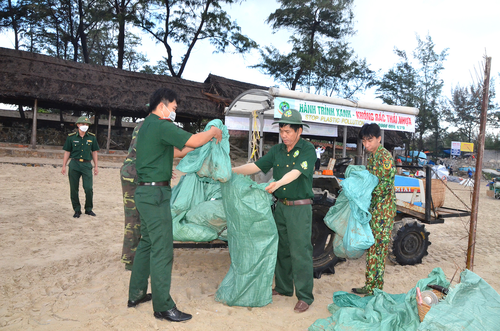 Anh Vũ Văn Mạnh (thứ 2 từ phải qua) cùng các chiến sĩ Đồn biên phòng Chí Linh thu gom rác ở bãi biển  Long Cung - Thủy Tiên.