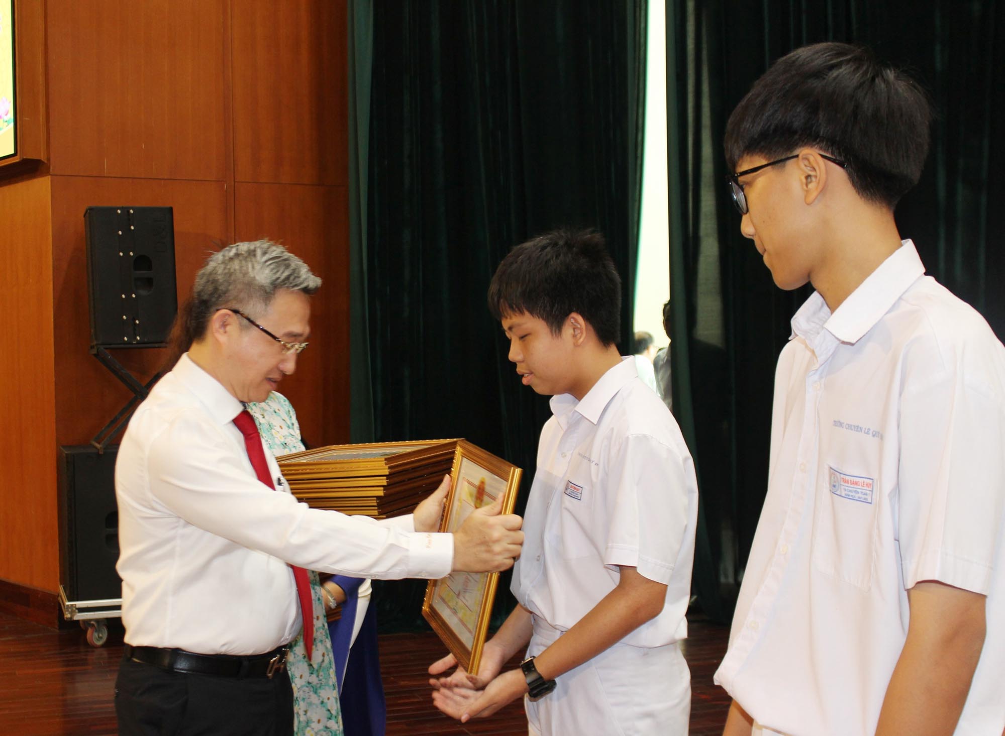 Ông Đặng Minh Thông, Phó Chủ tịch UBND tỉnh trao Bằng khen của UBND tỉnh cho HS đạt thành tích xuất sắc được tuyên dương tại buổi lễ