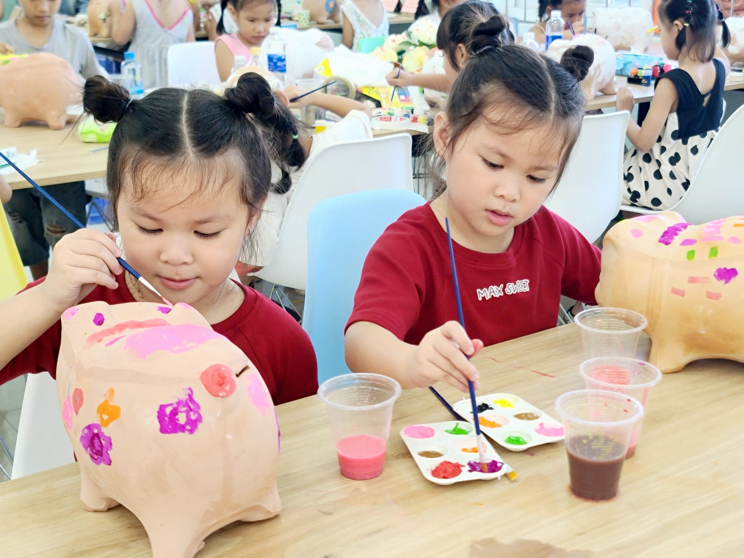 Các bé trang trí heo đất.