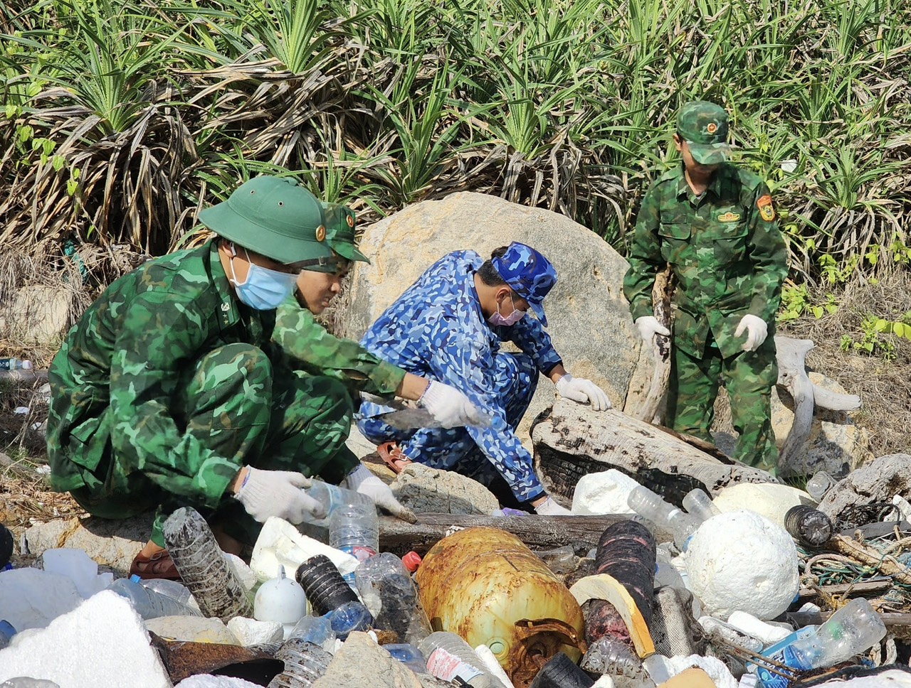 Cán bộ, chiến sĩ thu gom rác thải trên bờ biển Côn Đảo.