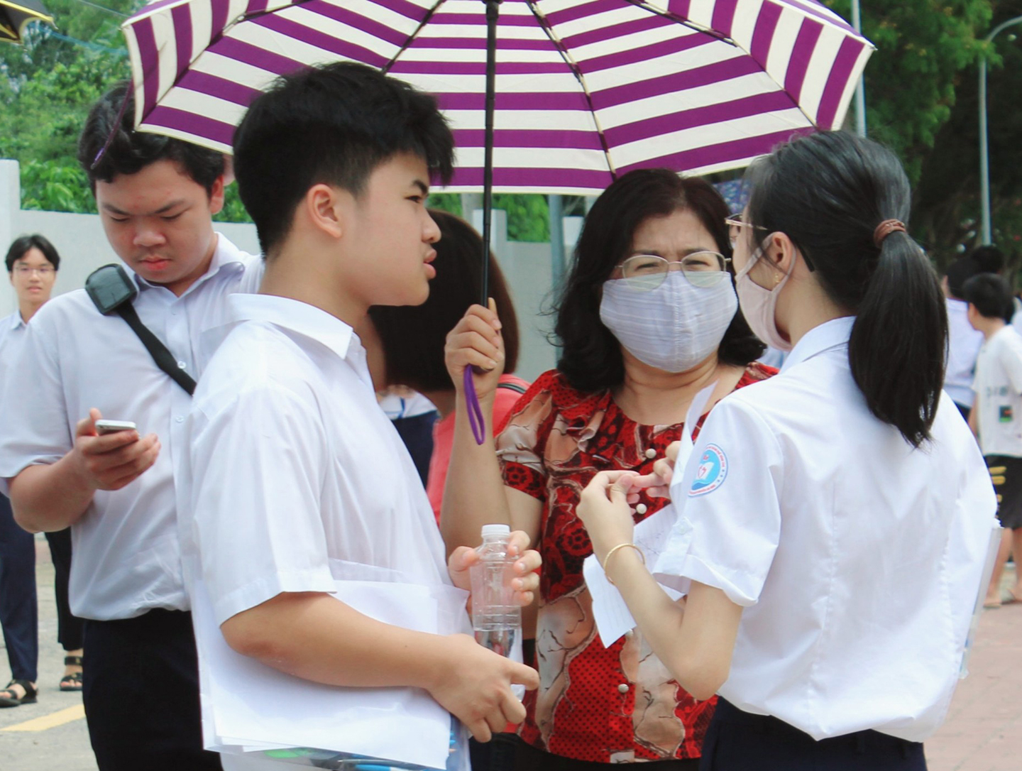 Phụ huynh tại điểm thi THPT chuyên Lê Quý Đôn động viên con sau khi hoàn thành bài thi Toán. Ảnh: KHÁNH CHI