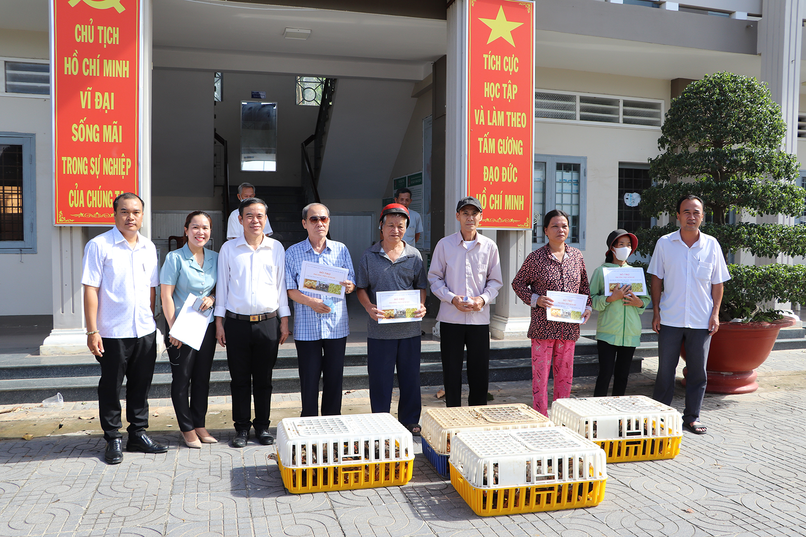 Đại diện MTTQ huyện, MTTQ xã trao gà giống đến các hộ nghèo.