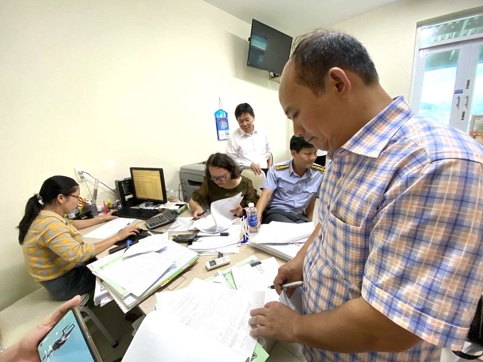 Đoàn công tác đối chiếu nhật ký theo dõi tàu cá tại cảng Hưng Thái