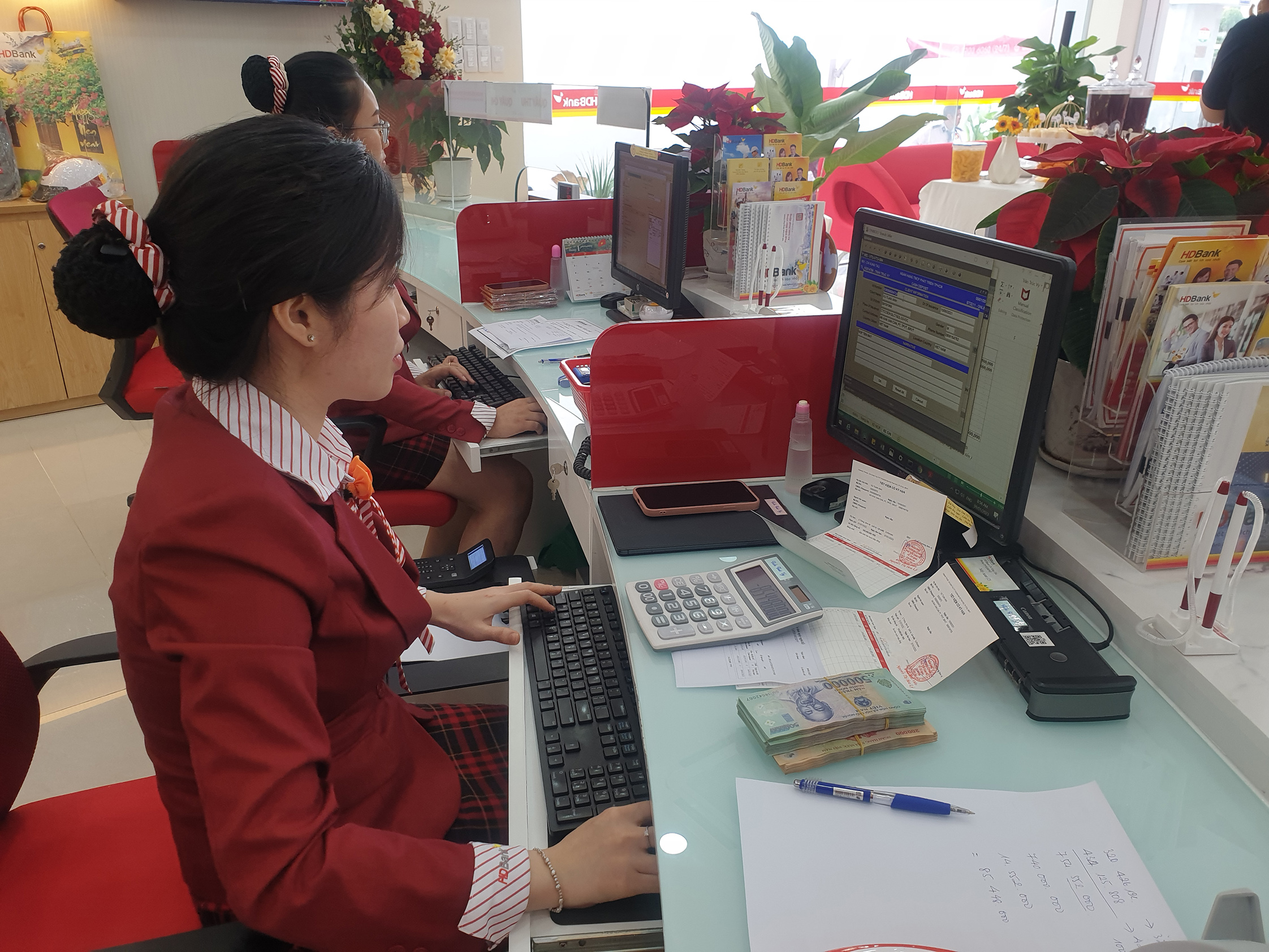 HDBank có tới 3 lần giảm lãi suất trong tháng 6. Trong ảnh: Nhân viên HDBank- Chi nhánh Vũng Tàu thực hiện giao dịch cho khách.