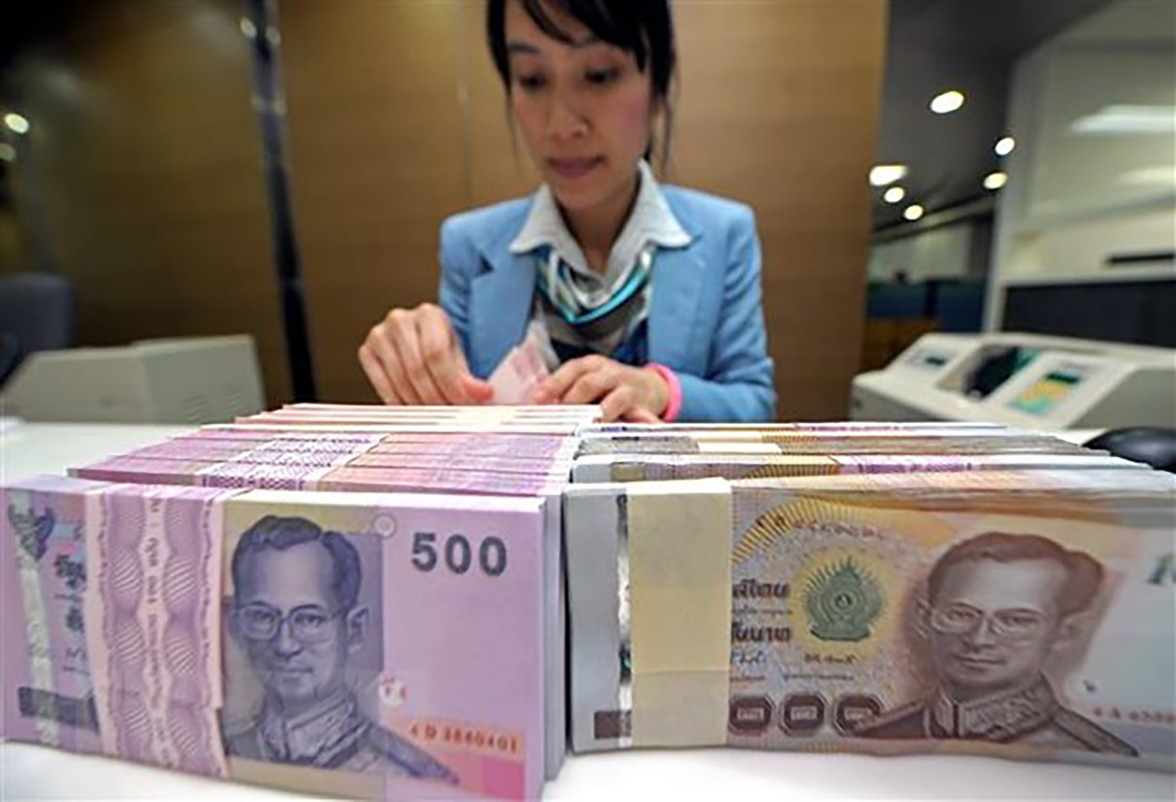 Nhân viên ngân hàng kiểm đếm đồng Baht tại Bangkok, Thái Lan.