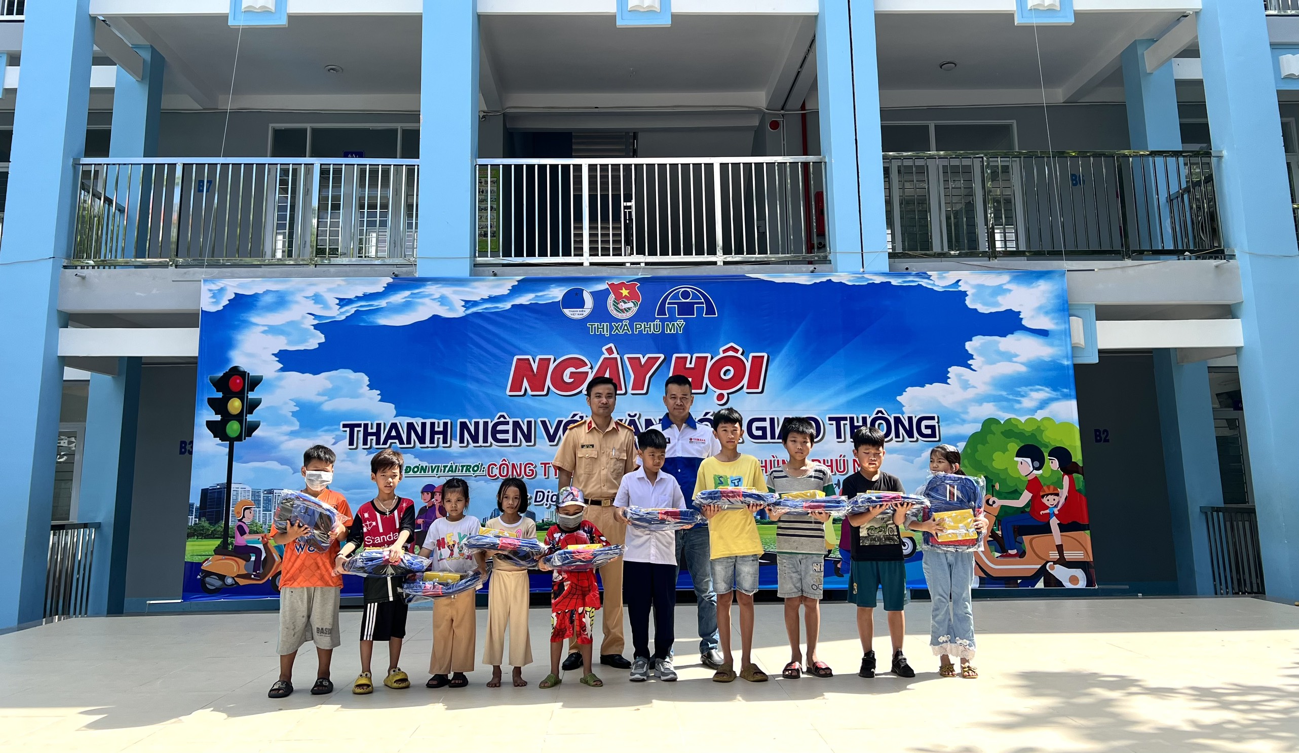 Công an TX.Phú Mỹ và đại diện Công ty Yamaha Mạnh Hùng  Phú Mỹ tặng quà cho thiếu nhi có hoàn cảnh khó khăn tại ngày hội.