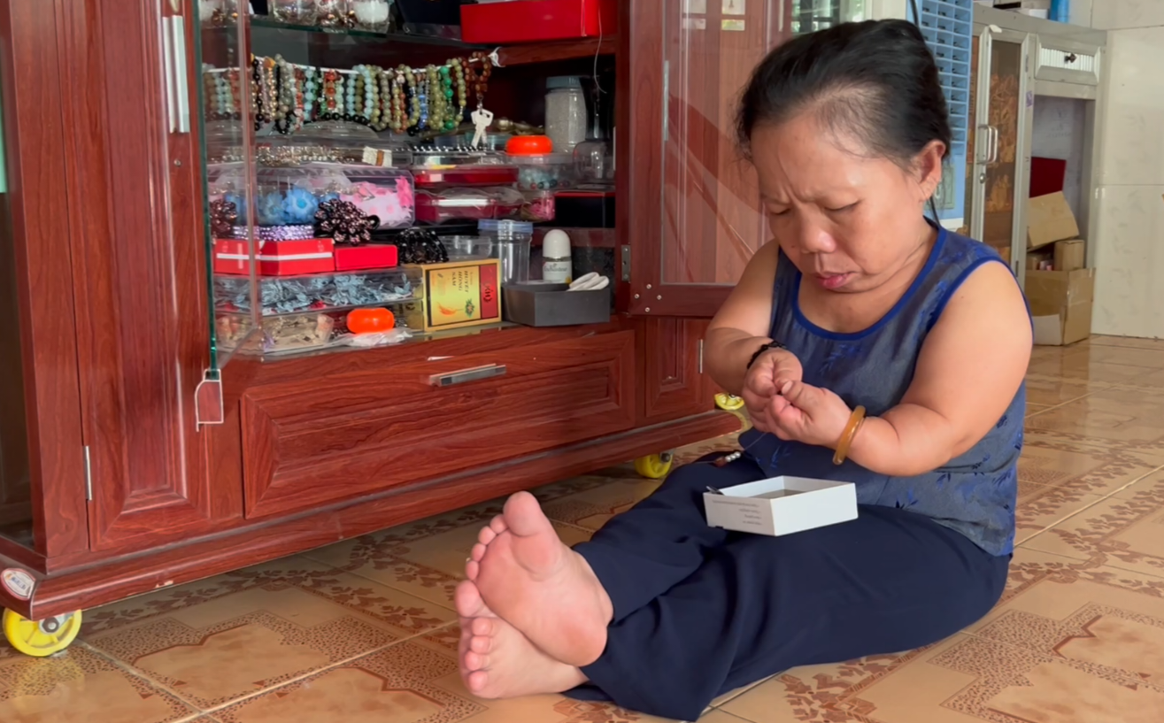 Chị Anh Thư cần mẫn xâu hạt chuỗi mỗi ngày mang lại thu nhập ổn định.