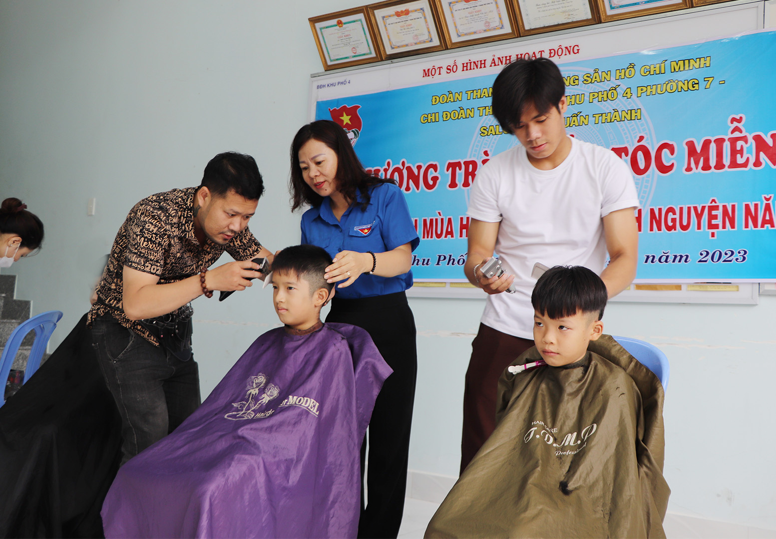 Các tay kéo của Salon Calvin Tuấn Thành cắt tóc cho người dân.