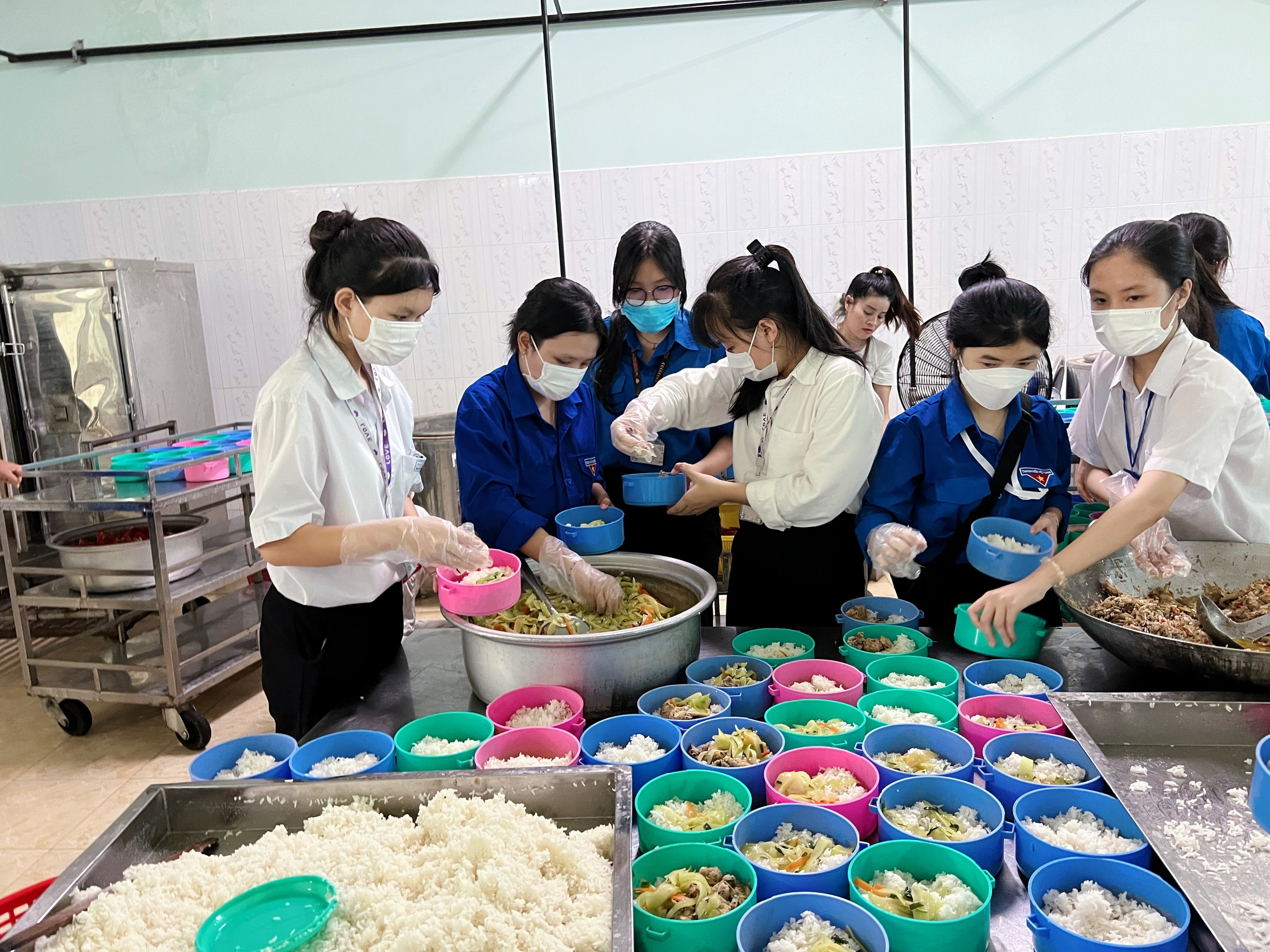 Tình nguyện viên chia thức ăn thành từng phần, bữa trưa ngon miệng, đầy đủ chất dinh dưỡng được sẵn sàng để mang tới cho các bệnh nhân đang điều trị nội trú tại Bệnh viện Tâm thần tỉnh.