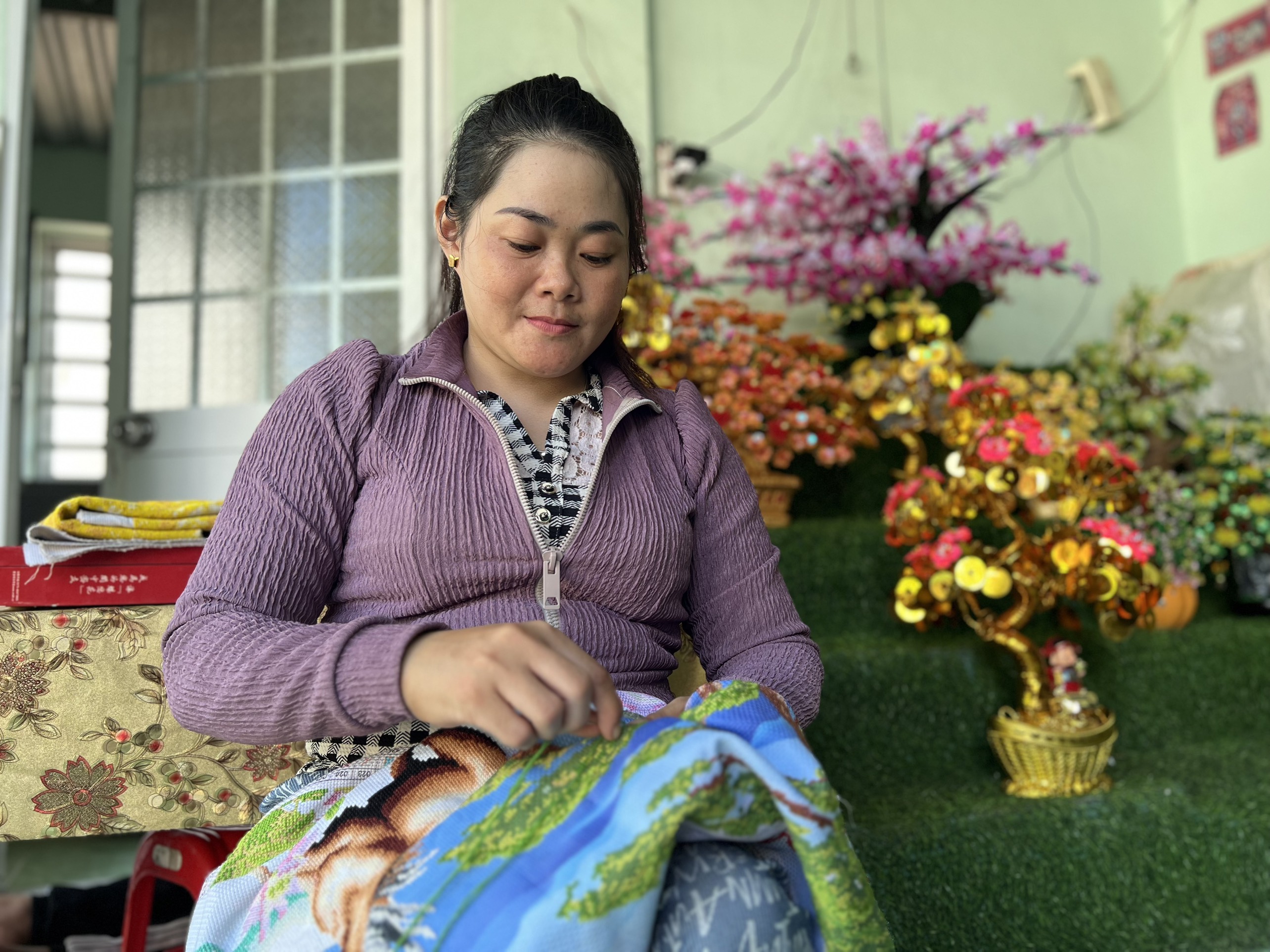 Chị Linh thêu tranh cho khách.