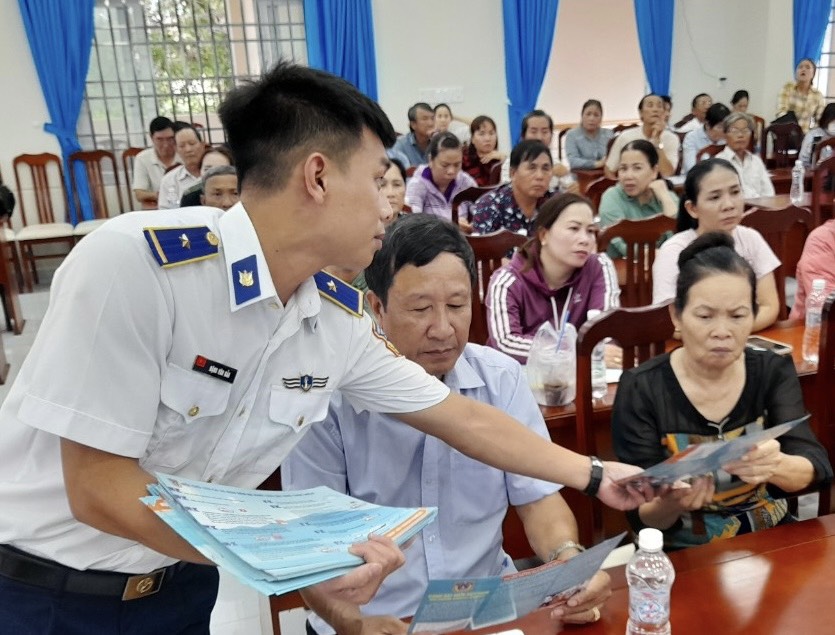 Cán bộ Vùng Cảnh sát biển 3 phát tờ rơi tuyên truyền về phòng, chống IUU cho cán bộ, đảng viên và nhân dân huyện Long Điền.